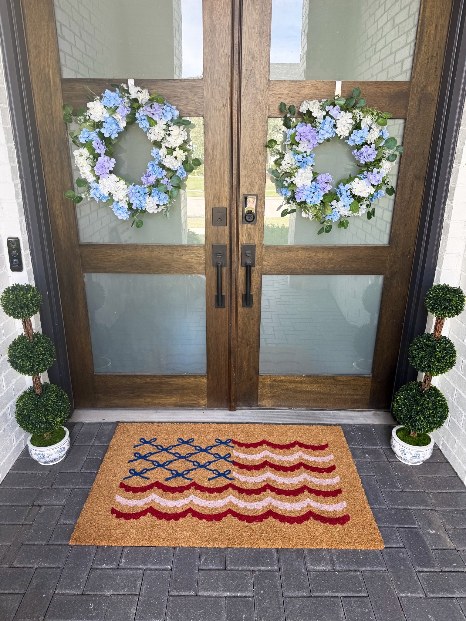 Spring porch , summer porch 
Red, white and blue porch 
Hydrangeas 
Chinoiserie topiaries 
Doormat 


#LTKHome #LTKSeasonal