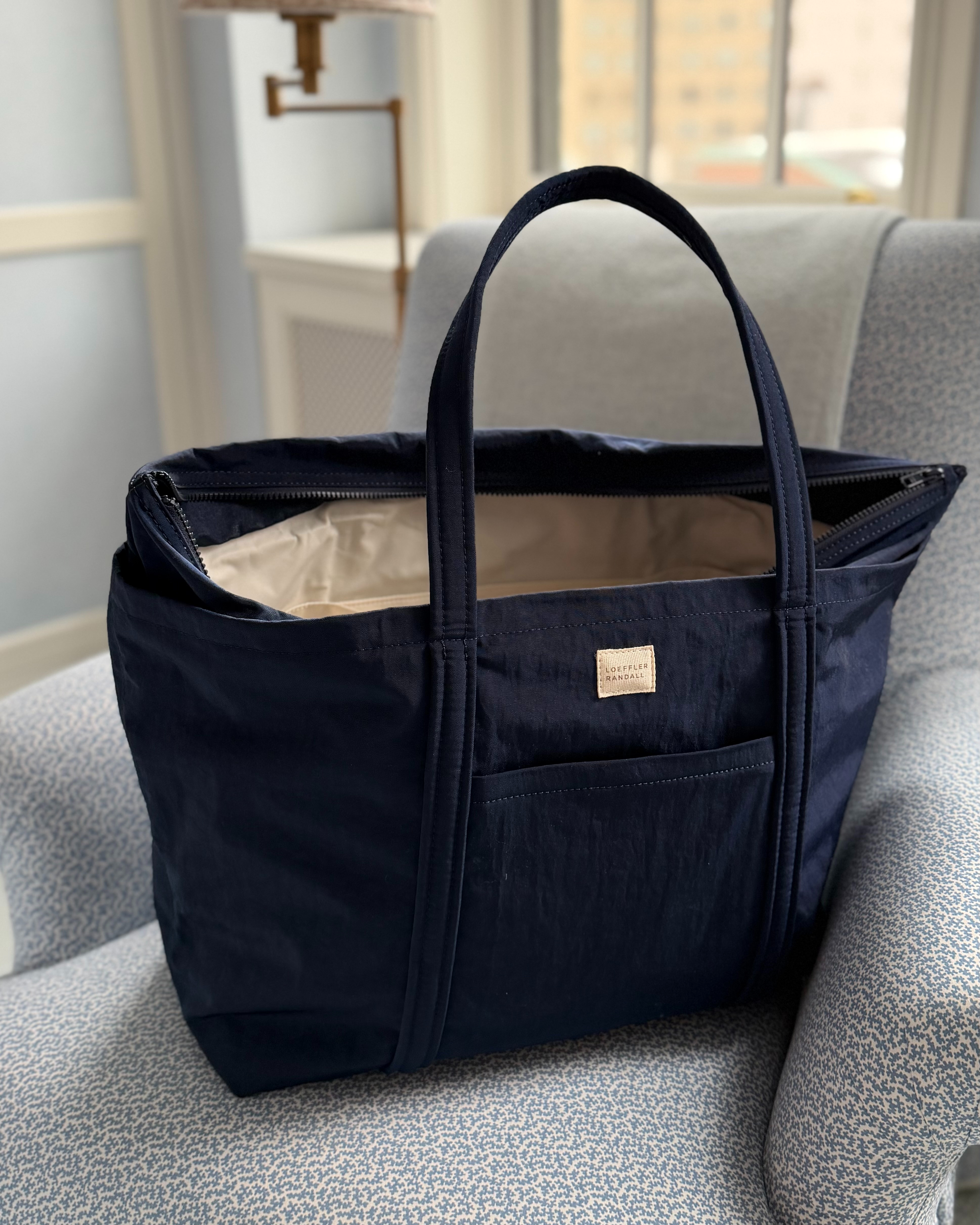A perfect travel or gym bag: The Dina Tote from Loeffler Randall. 

It has a top zipper, multiple interior pockets, a outside phone pocket and a luggage sleeve. 
#travel #traveltote #luggage  

 #LTKdayinmylife
