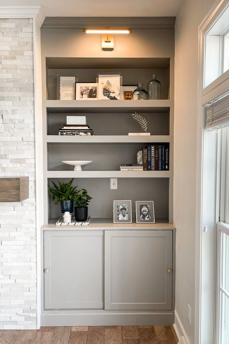 Living room built in shelves around the fireplace; bookshelf styling, brass picture light.  Paint color: Darrow and Ball Lamp Room Gray

#LTKhome #LTKfamily #LTKstyletip
