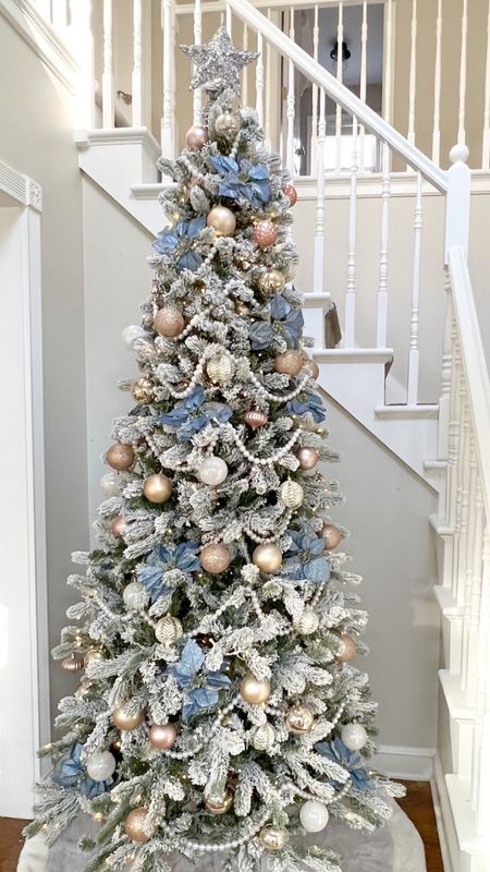 My 8’ king flock slim king of Christmas tree is currently on sale. Grandmillennial Christmas Tree with pearl garland, blue pointsettias, pink, rose gold & iridescent ornaments, and a neutral tree skirt. Pastel Christmas, chinoiserie, blue & white, flocked tree, artificial tree, skinny tree, pencil tree. Feminine Christmas. 

#LTKSeasonal #LTKHoliday #LTKhome
