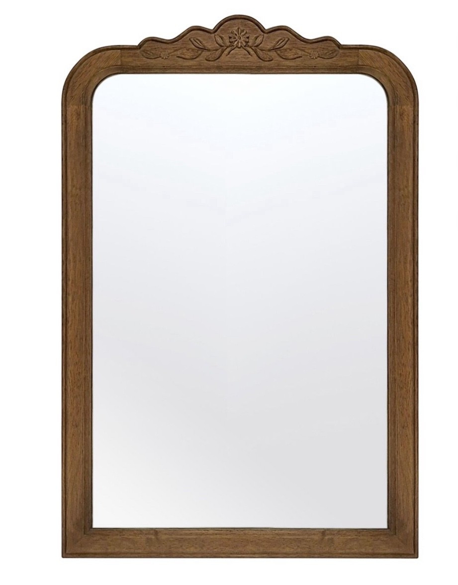 Turn up the charm in your home with the My Texas House Ornate Floral Carved Wood Mirror 24x36. This vanity size mirror features an ornate-shaped mid-tone wood frame with a detailed floral design carved on top. At 24x36x0.87, this mirror is perfectly sized for leaning or mounting to a wall with two pre-installed D-ring hangers. Created by home décor blogger and influencer Erin Vogelpohl, My Texas House décor reflects Erin's signature modern farmhouse and fresh country style