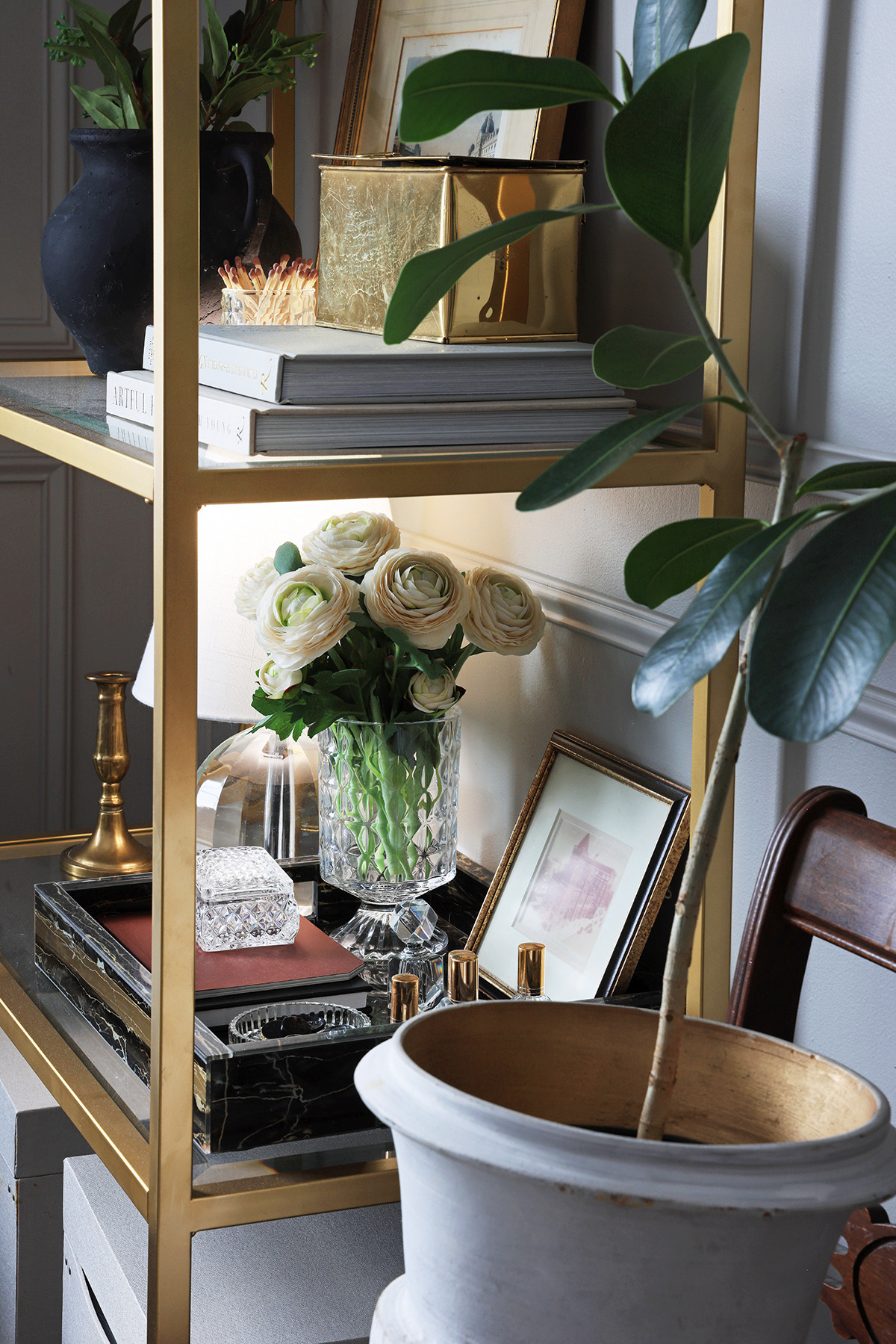 Bookcase styling | Lifelike artificial Rununculous flowers in an embossed glass vase | Small glass lamp | Black marble tray | Decorative coffee table books on home decor | Brass storage box | Matches in glass holder 

 #LTKHome