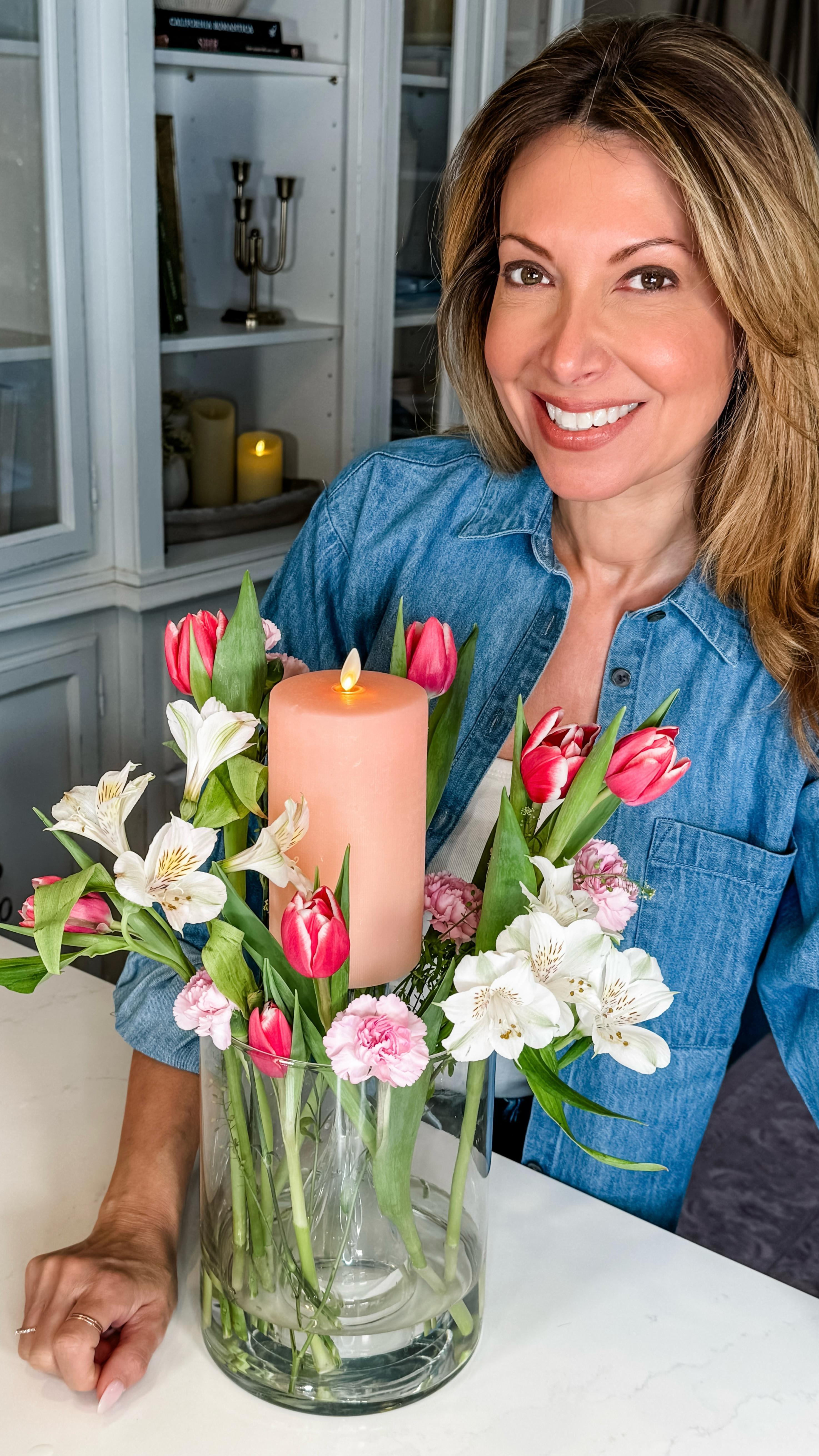 Candle + Flower Arrangement 🌷🕯️ Transform your vase of flowers into a captivating centerpiece with this 2-in-1 technique: use an upside-down stemware glass as a candle pedestal to lift your candle, creating a striking focal point. Surround it with fresh blooms for a beautiful contrast that adds height and charm to any table. This simple method seamlessly combines floral beauty and warm ambiance, making your decor truly special! 💖✨ 

Date Night
Floral DIY
Spring Centerpiece 