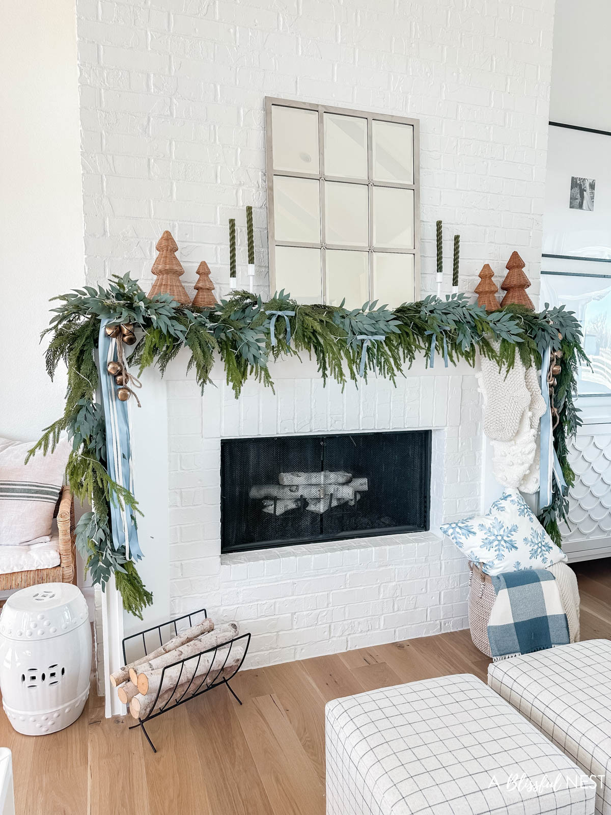 Loving a look back at my Christmas living room from last year with soft neutrals, greenery, and cozy layers throughout. Shop snag or grab the decor here.
blue velvet bows, woven Christmas cone tree, Norfolk Pine Christmas garland, olive green taper candles, candlestick holders, dusty blue satin ribbon, ivory velvet ribbon, vintage cluster cow bells on rope, upholstered cube ottoman, fairy lights, snowflakes pillow, cream stripe pillow, blue checkered throw blanket, decorative birch log, metal log holder 

 #LTKHoliday #LTKSeasonal #LTKHome