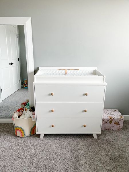 Nursery furniture! This dresser from Amazon is so heavy & sturdy! Very impressed. It comes with a removable wooden top for a changing pad that attaches to the back so the dresser top looks nice without it. I switched out the white round knobs for wooden ones I found on Amazon. I also bought drawer dividers for all her little outfits. Rainbow basket is so adorable from Target. Perfect for holding toys. 

#LTKfamily #LTKbaby #LTKhome