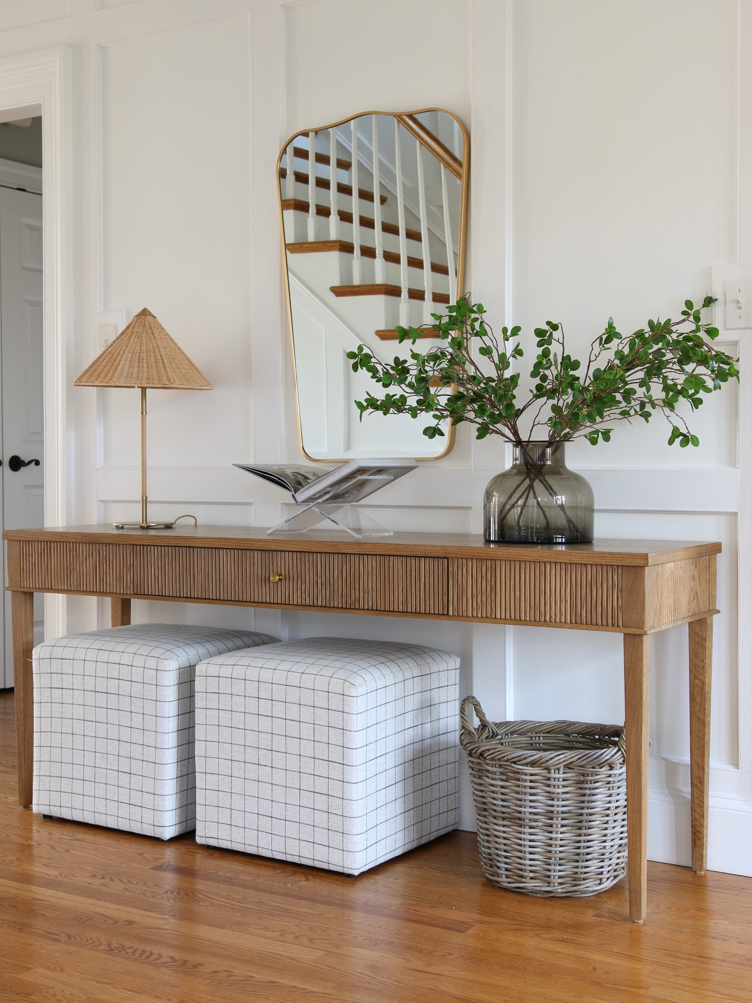 A current view of my hallway. I love this textured white oak console table from McGee and Co. I stayed it with a rattan table lamp, metal curved mirror, and upholstered cubes. I also used a rattan round planter and acrylic book holder.

#LTKstyletip #LTKFind #LTKhome