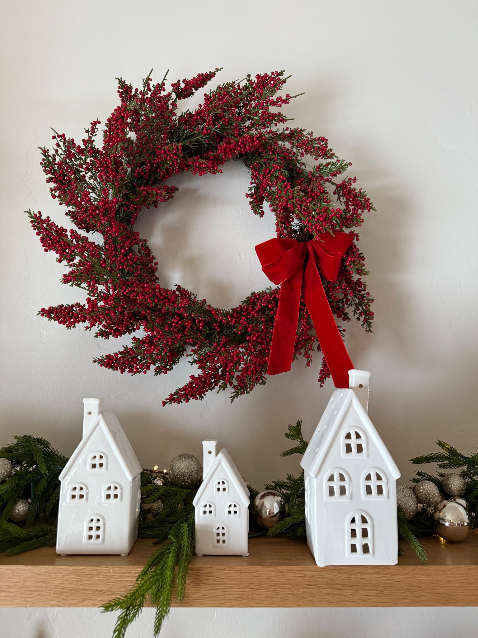 This whole look is so simple but feels so magical.
The berry wreath comes with the velvet bow already attached, and the greenery garland behind it sets the whole scene for these little ceramic houses to glow.
Effortless, festive, and so pretty.

#christmasdecorideas #holidayhomestyle #shelfdecor

#LTKHoliday #LTKHome