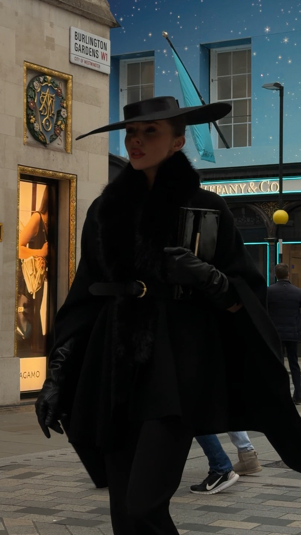 A statement winter look in all black. A tailored cape with a fur collar, cinched with a sleek black belt, paired with a black pencil maxi skirt, black sock boots, and black leather gloves. Finished with a structured black clutch and a wide brim boater hat in felt. Timeless elegance for any city stroll.

Hat is from Rose Cherie Paris and I have a discount code LAURA10 but I can’t link on LTK.