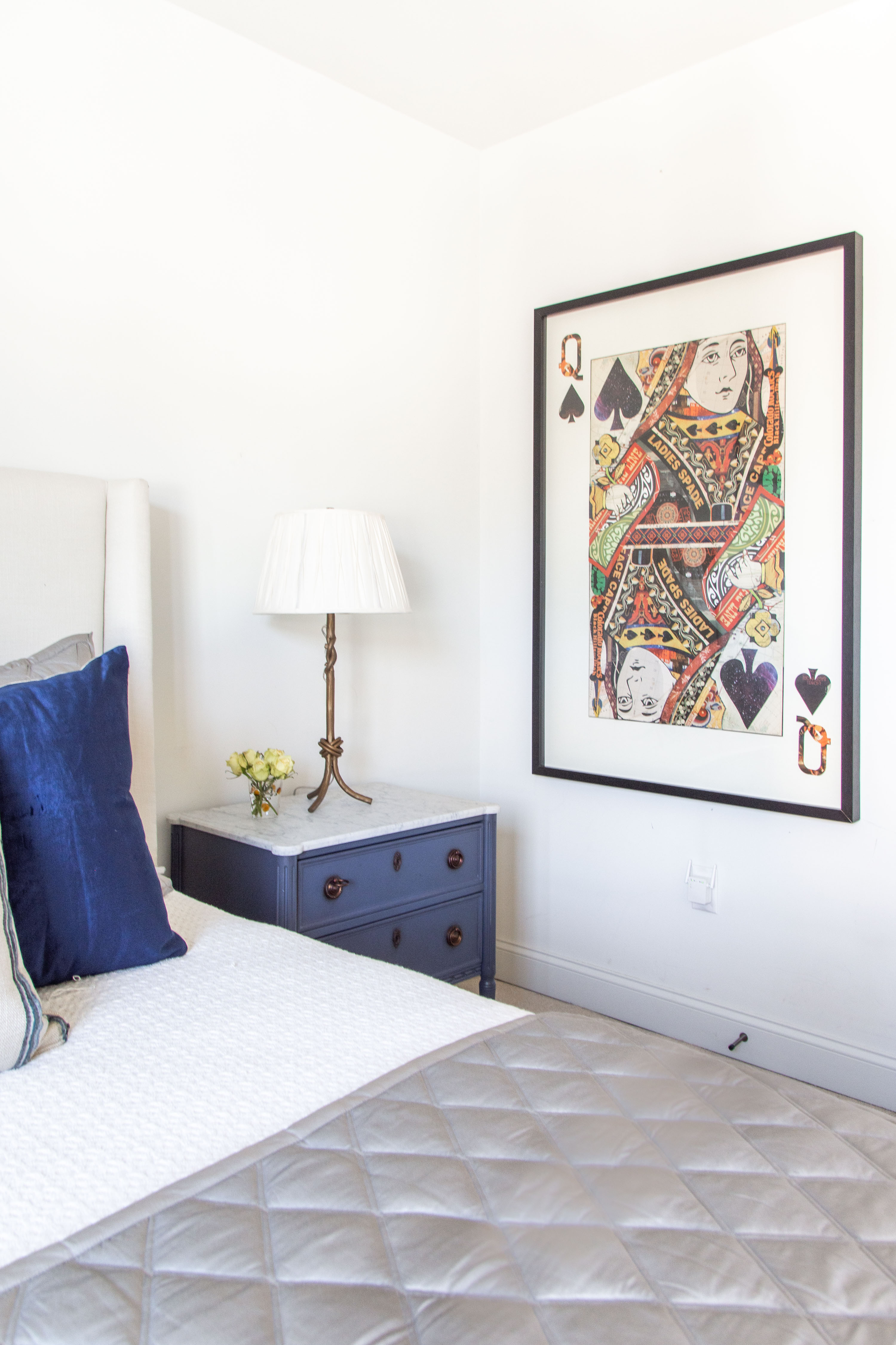 Cozy bedroom design inspiration featuring a bold statement art piece, a modern navy nightstand with marble top, and elegant brass table lamp. I styled this look with crisp white bedding, a quilted gray coverlet, and plush navy velvet throw pillow for layered texture and timeless sophistication. Perfect mix of contemporary and classic style for a chic bedroom refresh. Shop this look for framed wall art, designer bedding, luxury throw pillows, and nightstand decor ideas. 

 