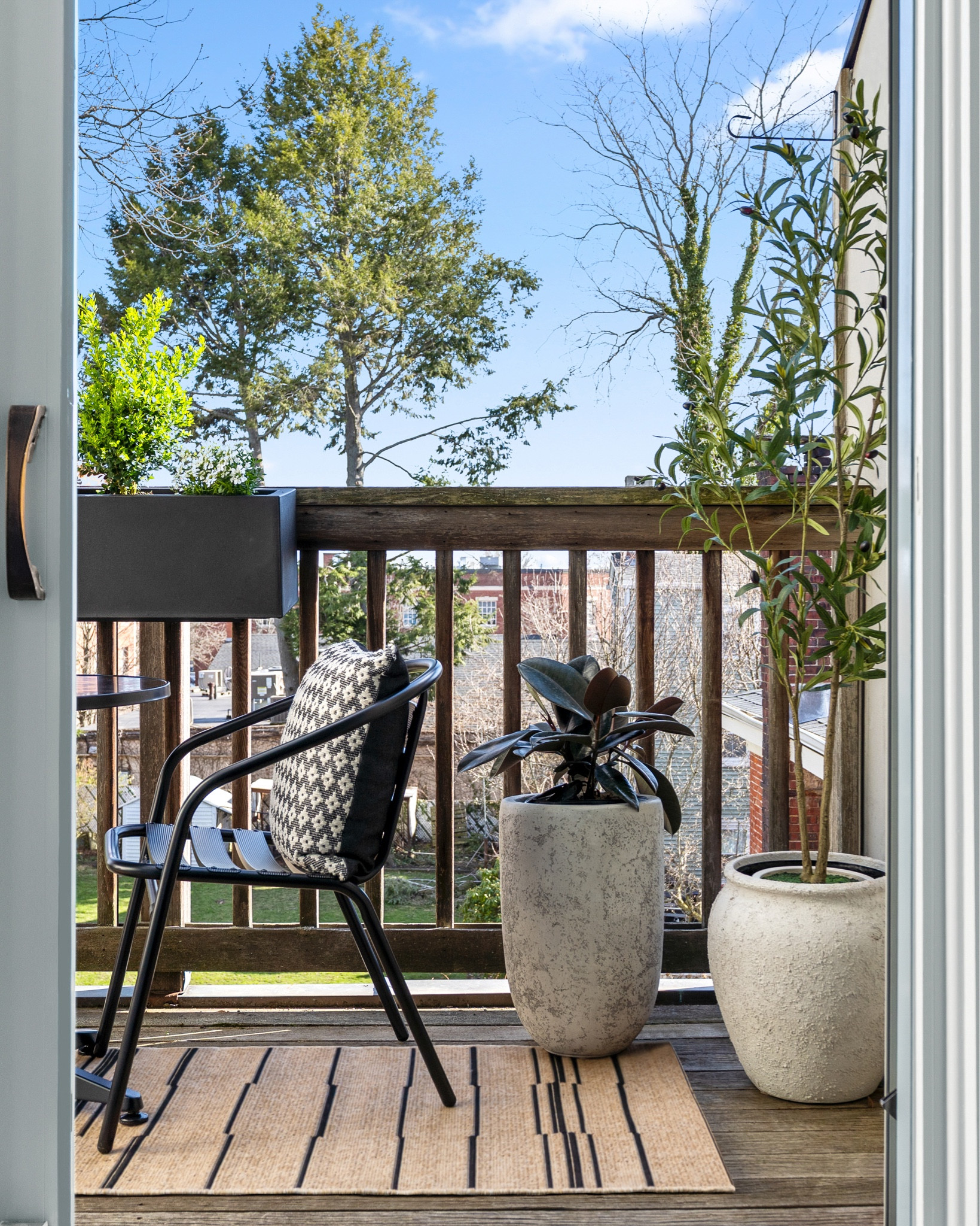 #AD it's time to reveal the transformation of the #dwelloctoberstudio church to condo revival balcony! we teamed up with @Lowe's to convert this underutilized space into an outdoor oasis just in time for spring. all of the products we used are available @Lowe's and prove that it's possible to create a chic outdoor space when working with a limited budget. when designing this space, we were inspired by a neutral striped outdoor rug and used it as the backdrop for a cozy seating area featuring a black metal bistro set. next, we introduced a lot of greenery into the space using cement-look planters filled with an olive tree, rubber tree, as well as a railing planter with boxwoods and candytuft flowers. rattan lanterns and black-and-white geometric throw pillows finish off the space with a cozy feeling. #LowesPartner #dwelloctober

#LTKHome