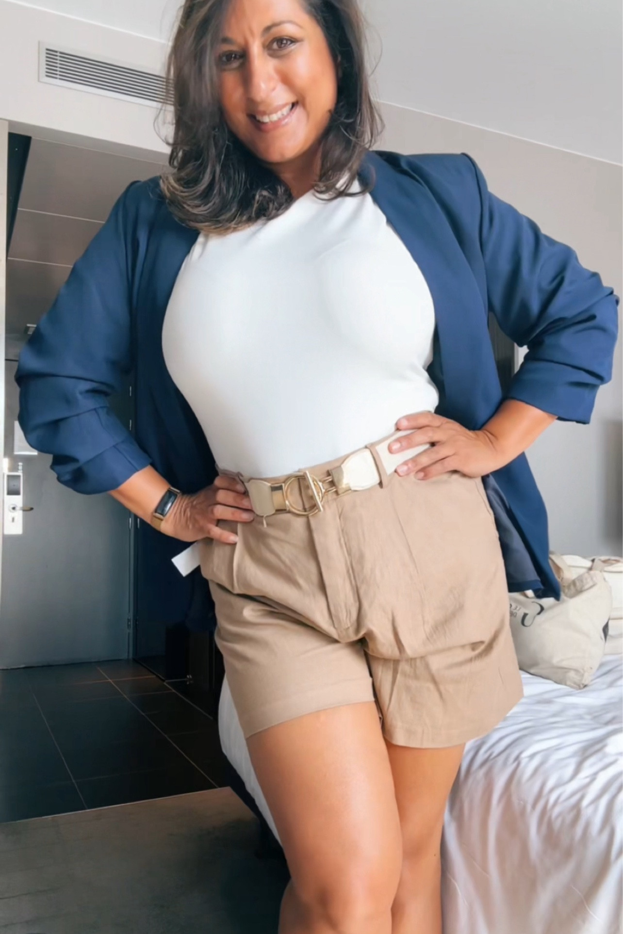 White top, tan shorts, blue blazer, belt 