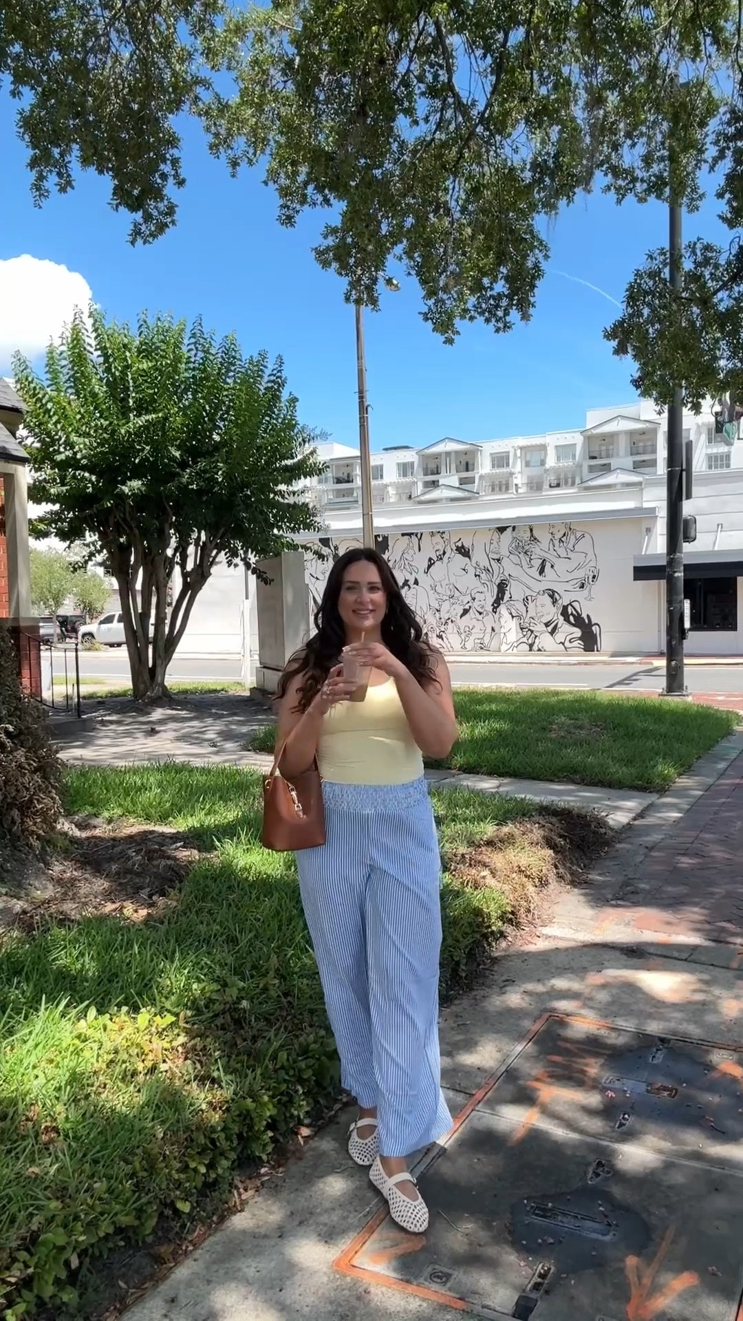Vacation outfit featured pinstripe pants (SO comfy), a tank top with built in bra, brown bucket bag and white square toe flats.

#LTKMidsize #LTKTall #LTKTravel