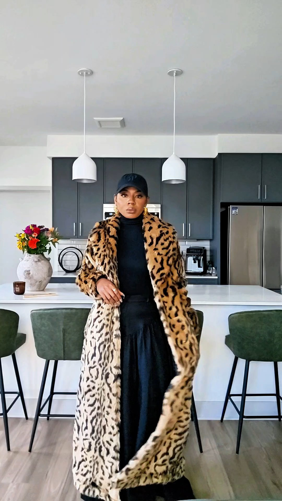 Chic Airport Outfit with a Floor Length Leopard CoatA floor length leopard coat will always do the heavy lifting. I styled this maxi leopard coat for the airport with an all-black base, wide-leg trousers, chunky loafers, and a cap for an effortless street fashion look that still feels comfortable enough for travel. This is real-life street style — polished, easy, and wearable.You don’t have to wear sweats to be comfortable when traveling. A pair of relaxed trousers or dress pants instantly makes you look more put together, and when they’re wide-leg and fluid, they’re just as comfortable for long flights.Style tip: when wearing a bold leopard coat, keep the rest of the outfit simple and tonal so the silhouette stays clean and elevated. A floor-length coat also doubles as a blanket on cold flights ✈️This outfit works beyond the airport too — I’d wear it for:• city walks• brunch• shopping• casual dinners• winter errandsSIZING:Coat: SmallPants: Small Shoes: 8Top: SmallWeight: 125lbsHeight: 5'4"

#LTKgrwm #LTKootd #LTKPetite