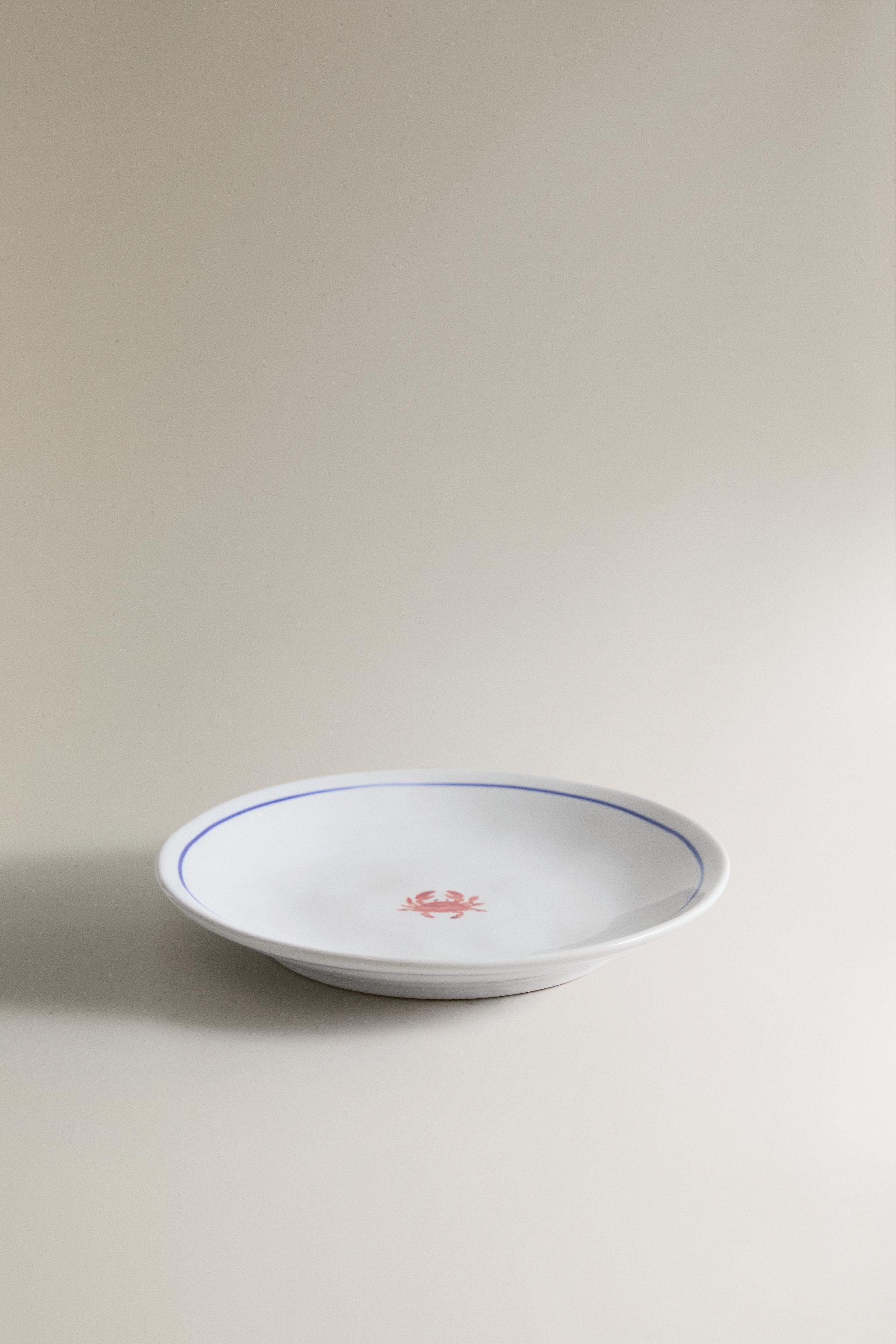 Stoneware side plate with a blue-edged rim. The design features a decorative motif of a small sea... | Zara UK