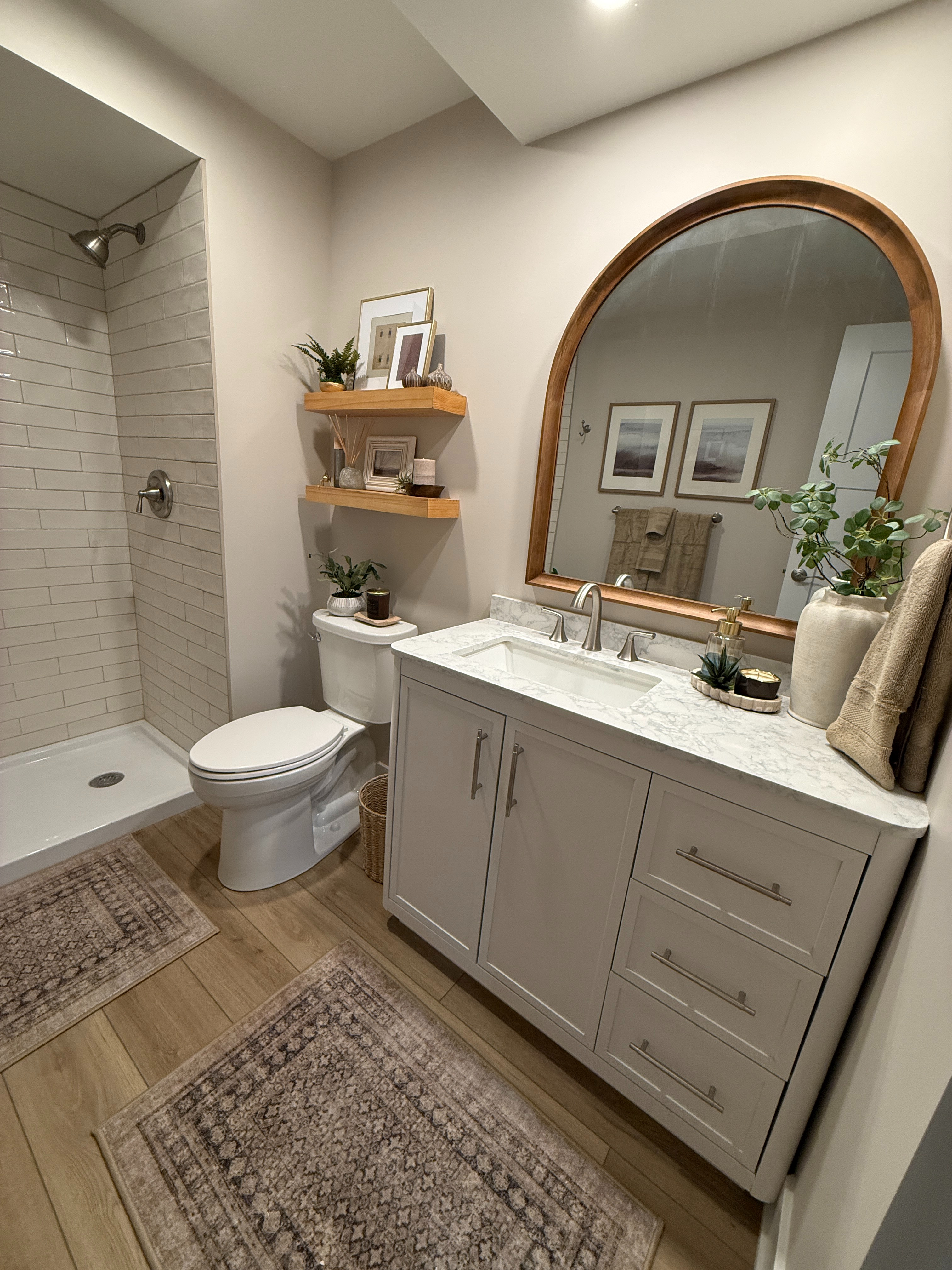 A basement bathroom renovation that feels like a main character moment. One of our favorite styles of washable rugs from Ruggable, a gorgeous wood arched mirror to add warmth and contrast to a crisp white vanity, and the budget friendly floating shelves we find ourselves reaching for time and time again.  

 #LTKHome #LTKSaleAlert