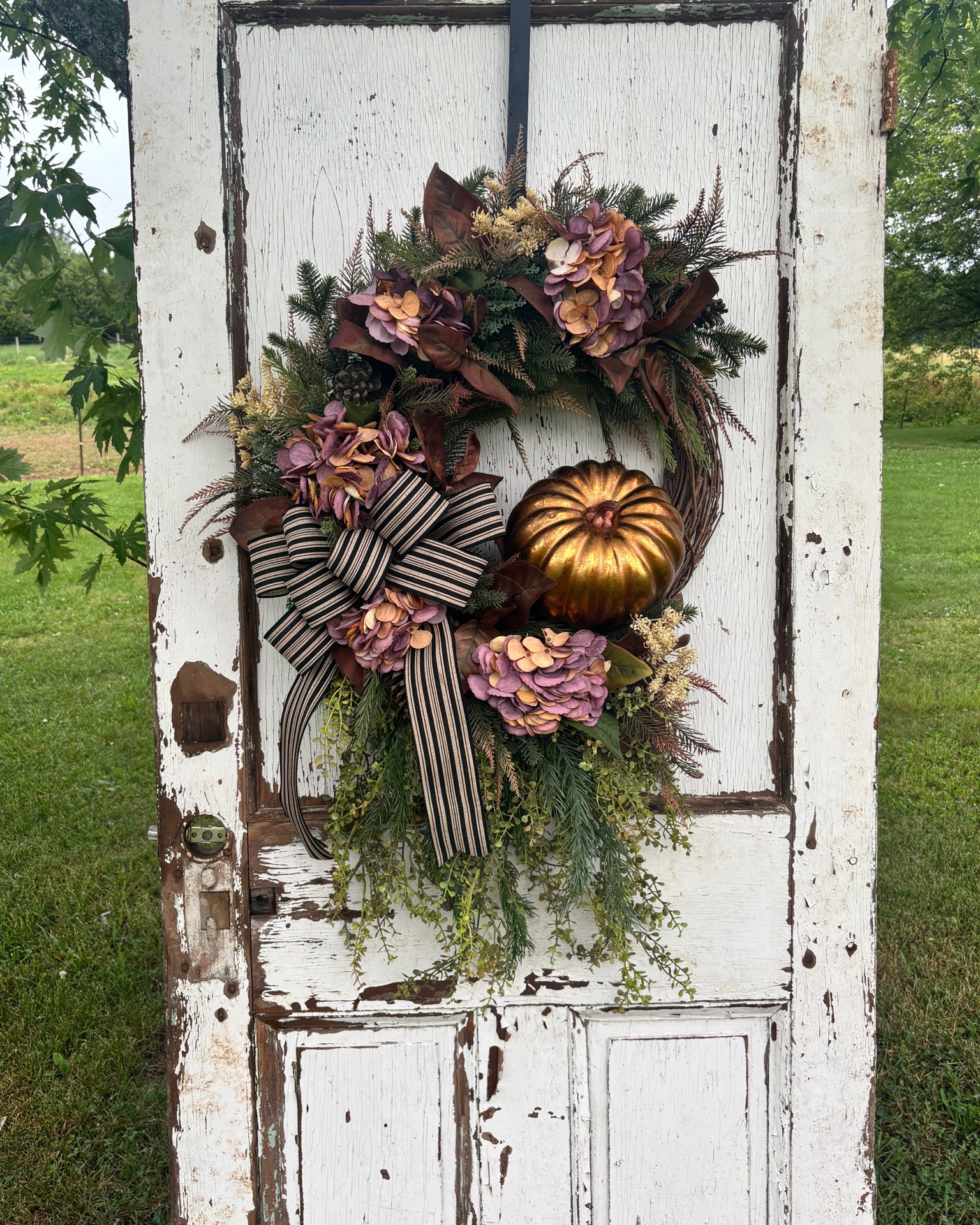 🍂 Now Available! 🍂

If you’re dreaming of a warm and welcoming front porch this fall, this one is ready to make a statement! Rich autumn hydrangeas, lush greenery, a gorgeous metallic pumpkin, and a classic striped bow come together for a timeless design that will carry you from early fall all the way through Thanksgiving.

✨ Only ONE available!

#LTKHome #LTKSeasonal #LTKU