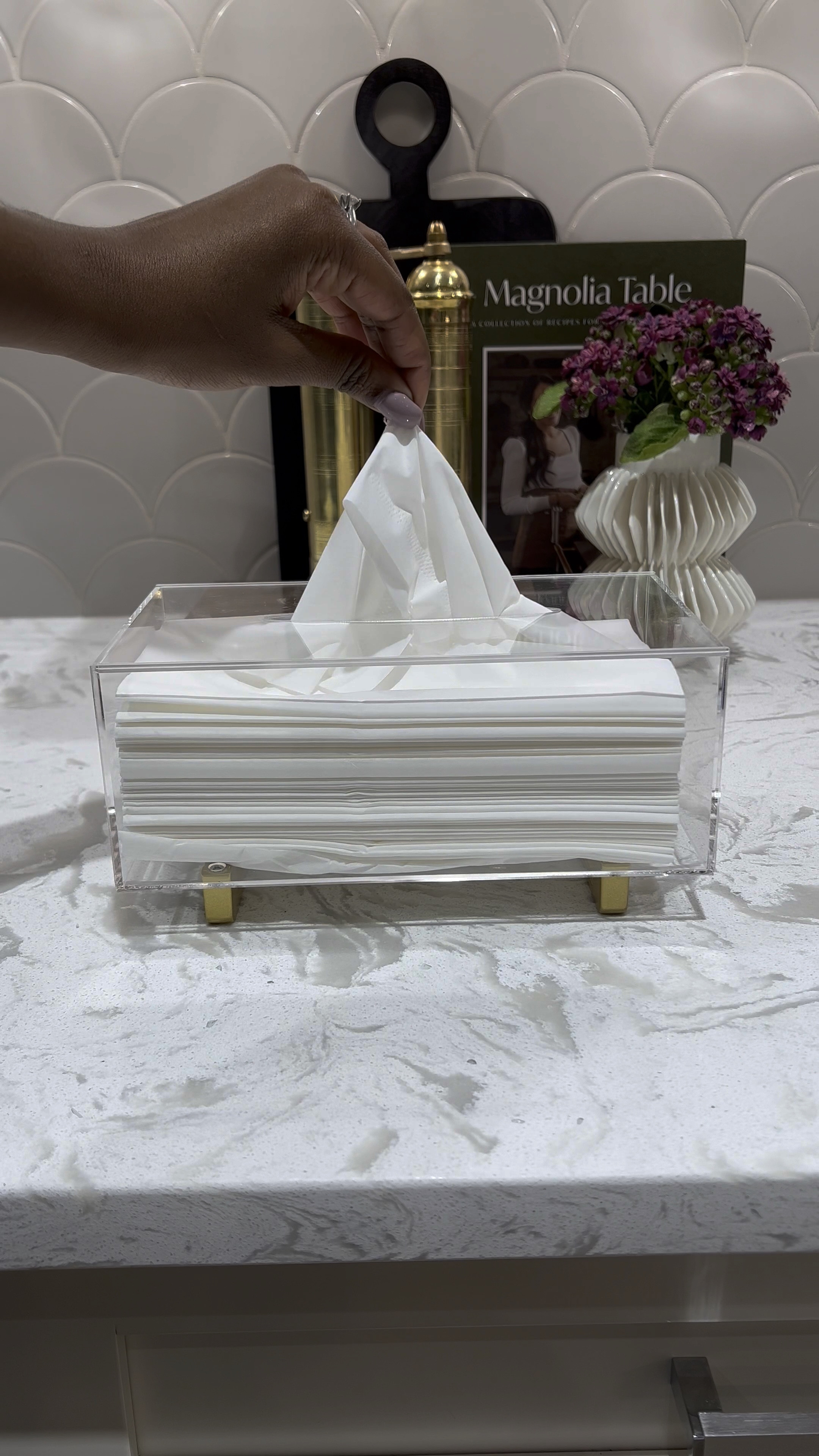 I love this acrylic tissue paper holder. It adds an elegant touch to any space. Style it on your bathroom or on any side table! 💕

Kleenex holder 
Tissue holder 
Salt and pepper mill 
Wooden pedestal tray
Small white vase
Countertop styling 
