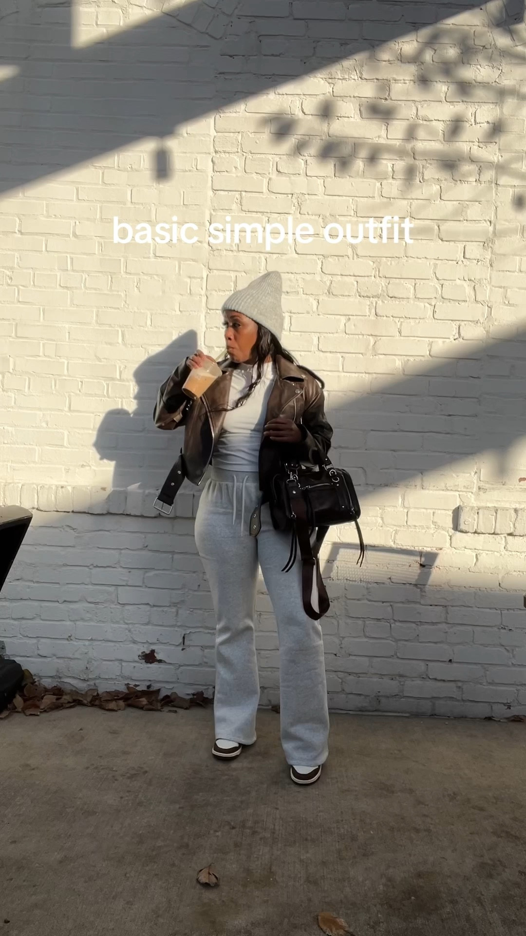 Basic simple outfit idea. Brown faux leather jacket, white fitted tee, gray sweatpants, gray beanie, and brown and white Nike dunk low sneakers.

#LTKFindsUnder50 #LTKPetite #LTKootd