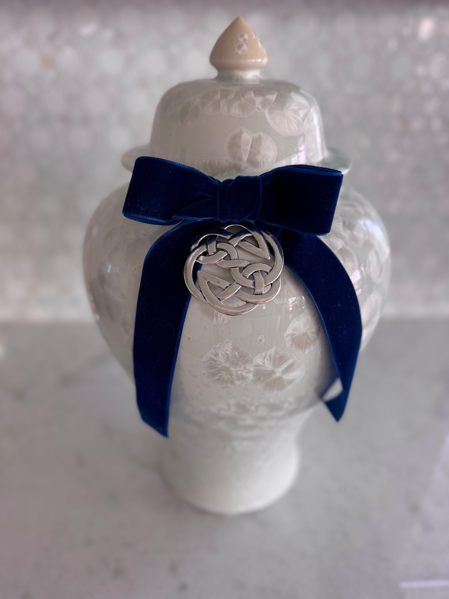A subtle and elegant way to add a Holiday Touch to beautiful Temple Jars. Use an ornament with a velvet bow and coordinate both with your Holiday Decor! So many beautiful velvet colors and ornaments. This is a Celtic Knot. 

#LTKHome #LTKHoliday #LTKSeasonal