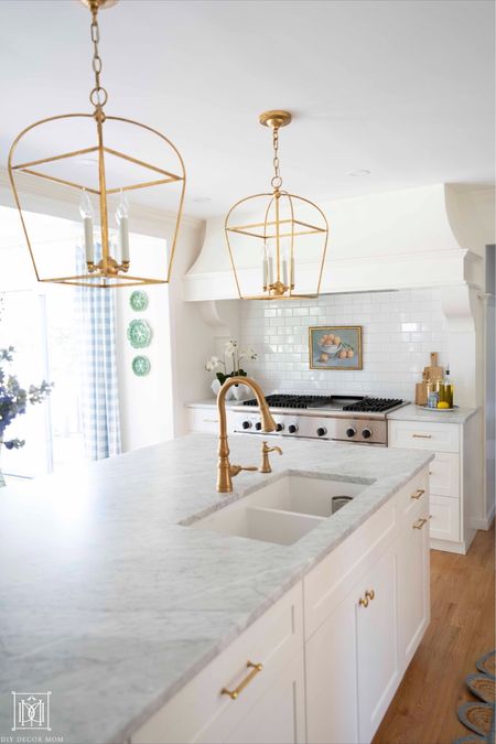 Gold Kitchen island pendants, gold kitchen lanterns, unlacquered brass hardware, Carrera marble, brass kitchen faucet pull down 