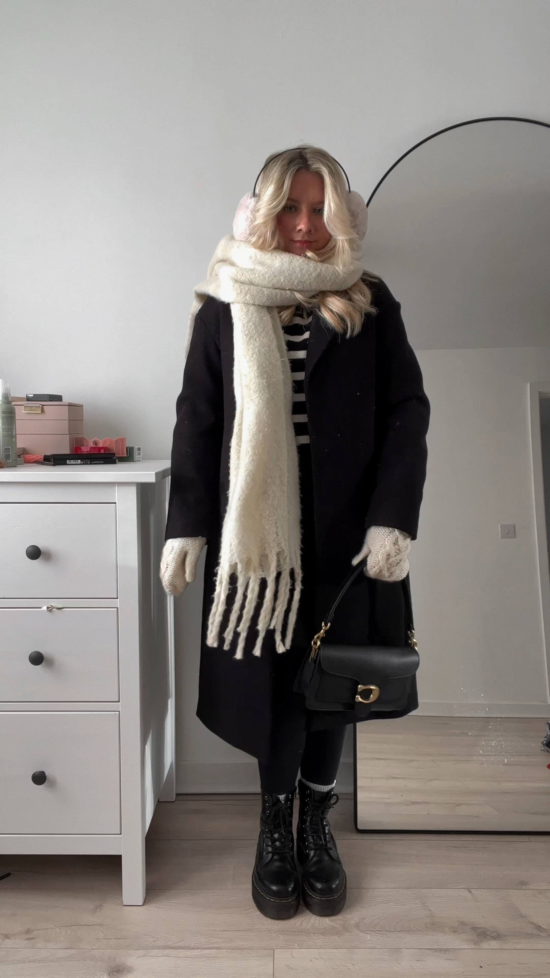 black ribbed seamless jumpsuit/unitard layered with a black ribbed long sleeve top, a striped turtleneck sweater, black chunky dr martens jadon boots, thermal socks, a black long coat, fluffy ear muffs, oversized cream scarf and mittens, and a coach tabby shoulder bag

#LTKFind #LTKstyletip #LTKeurope
