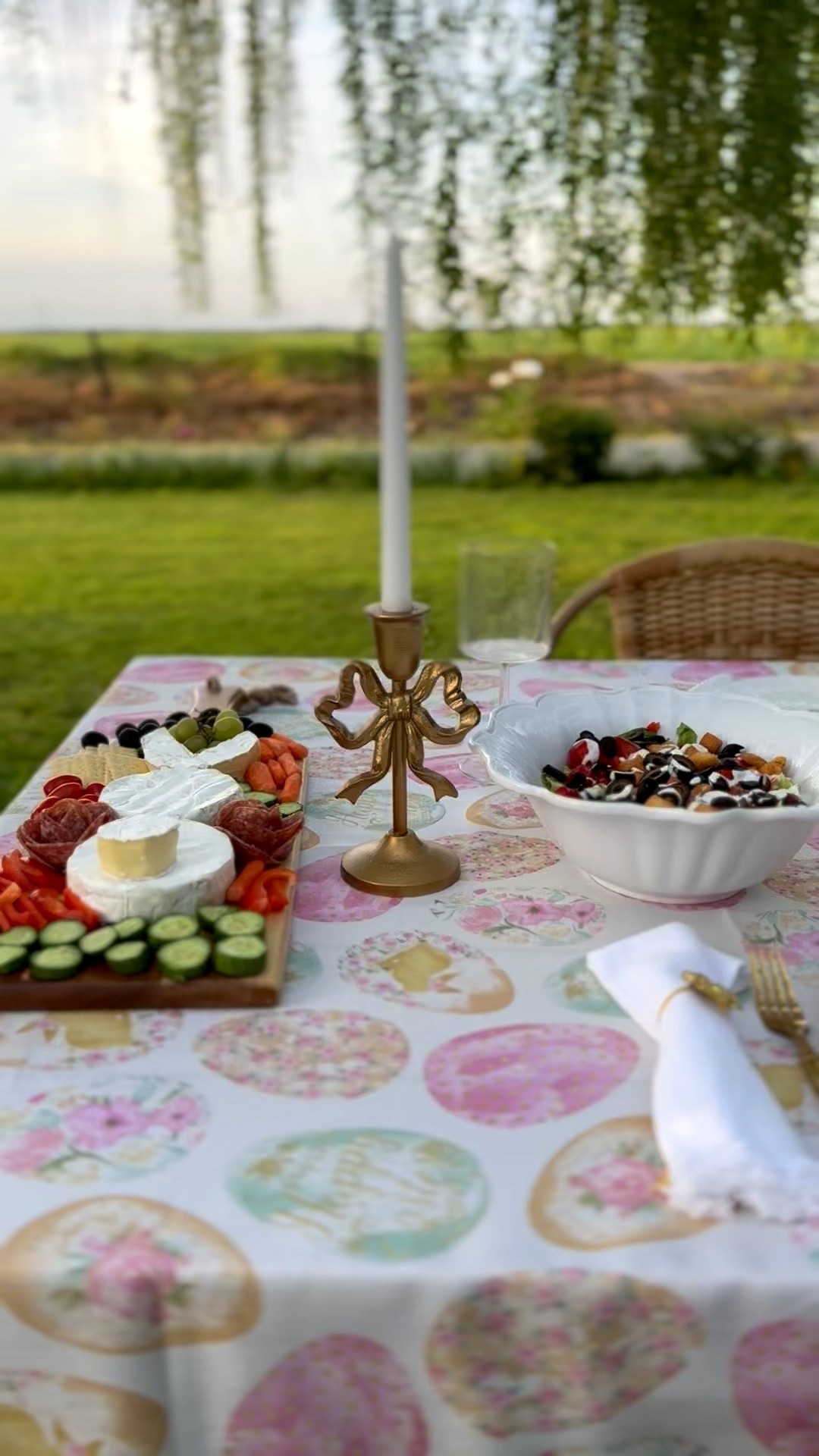 Easter tablescape idea with gold bow candlestick holders, delicious food a pretty Eastervegg tablecloth and entertaining essentials 💗