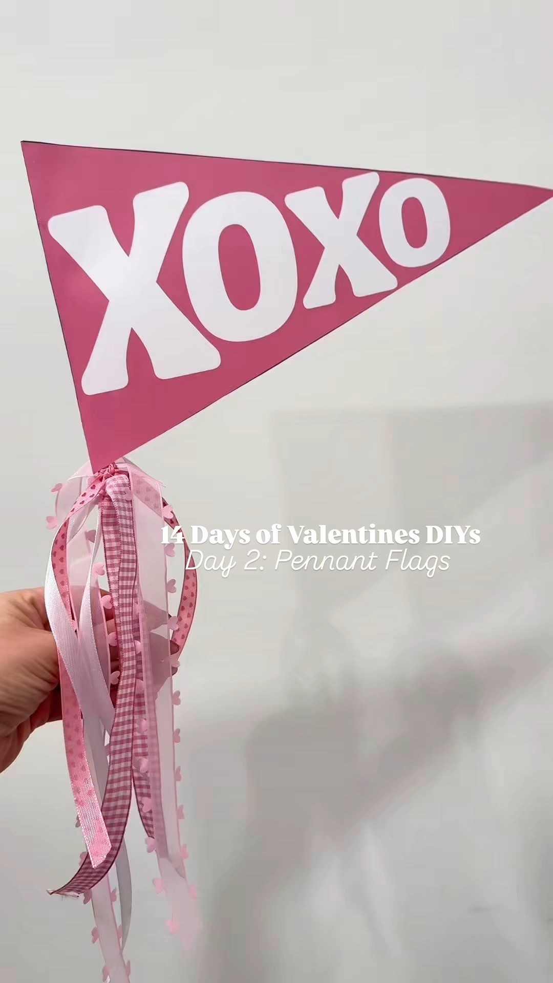 On day 2 of 14 Days of Valentine’s DIYs, we’re making pennant flags! These are always a favorite and they’re so easy to make. 

Put these in: 
🧺Love Day Baskets, 
🗓️February 1st Baskets, 
📖Playroom Decor, 
🍎or even make for class Valentines! 

Here’s my full tutorial: 
1) download the canva template that I made and use my design or create your own! Just DM me “FLAG”
2) Print on 100lb premium card stock 
3) cut out the flag and be sure to leave the flap in the margin to fold over the wooden dowel. Don’t forget to cut off the excess little triangles! 
4) Heat up the hot glue gun and grab your wooden dowel 
5) fold the white flap to the edge of the creative, it creates a sleeve for the dowel and hot glue 
6) place hot glue on the line that you folded and add the dowel, wrapping the paper around it. 
7) let it dry and then simply tie in your ribbon