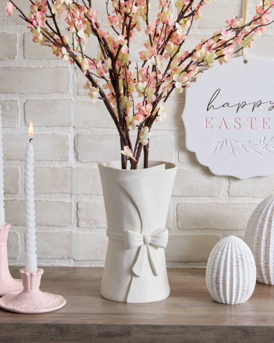 Bring timeless elegance to your Easter decor with the Large White Ceramic Vase with Bow (9.84”). Featuring a classic silhouette with a delicate bow detail, this vase adds a charming and sophisticated touch to any space. Its crisp white finish makes it perfect for displaying fresh spring florals or as a standalone statement piece on your mantel, table, or shelf. A beautiful blend of simplicity and festive charm! 

#EasterDecor #SpringElegance 

#LTKFindsUnder50 #LTKHome #LTKSeasonal