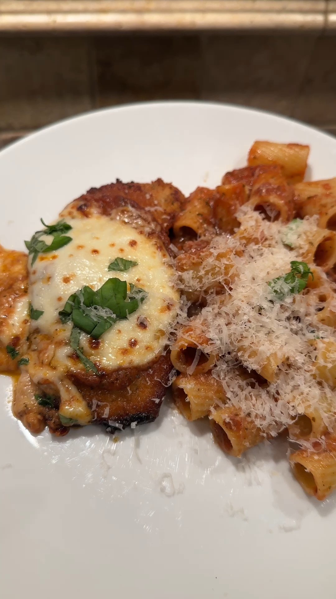  Chicken Parmesan

﻿Here's what you'll need:

2 packages of your favorite marinara sauce
2 chicken cutlets (recipe below)
1 package of fresh mozzarella cheese
1/2 cup of freshly grated parmesan cheese
1/2 lb of rigatoni
Handful of freshly chopped basil

Chicken Cutlets:
Thinly sliced chicken breast
1/3 cup half and half
1/2 cup panko bread crumbs
1/2 cup Italian bread crumbs
1/2 cup grated parmesan cheese
1 cup olive oil
4 tablespoons butter
Salt and Pepper
Granulated garlic
Italian seasonings

To make the chicken cutlets:
Add half and half, salt, pepper, garlic powder, and seasonings to the chicken breasts.
Mix panko, breadcrumbs, cheese, and seasonings in a separate bowl.
Press each side of the chicken into the breadcrumb mixture.
Heat up a pan with olive oil and butter.
Add chicken, two at a time to the pan and fry until golden brown on each side, flipping once.
Take out and drain on a plate with a paper towel.
Season with a sprinkle of salt, set aside.

Once all the chicken is cooked, add marinara to the top of each one. Top with 1-2 pieces of fresh Mozzarella.
Bake at 350° for 15 minutes or until cheese has melted.
Remove, top with fresh Parmesan and broil to brown for 1-2 minutes.
Serve on top of pasta with marinara and freshly chopped basil and enjoy!

#LTKKids #LTKFamily #LTKHome