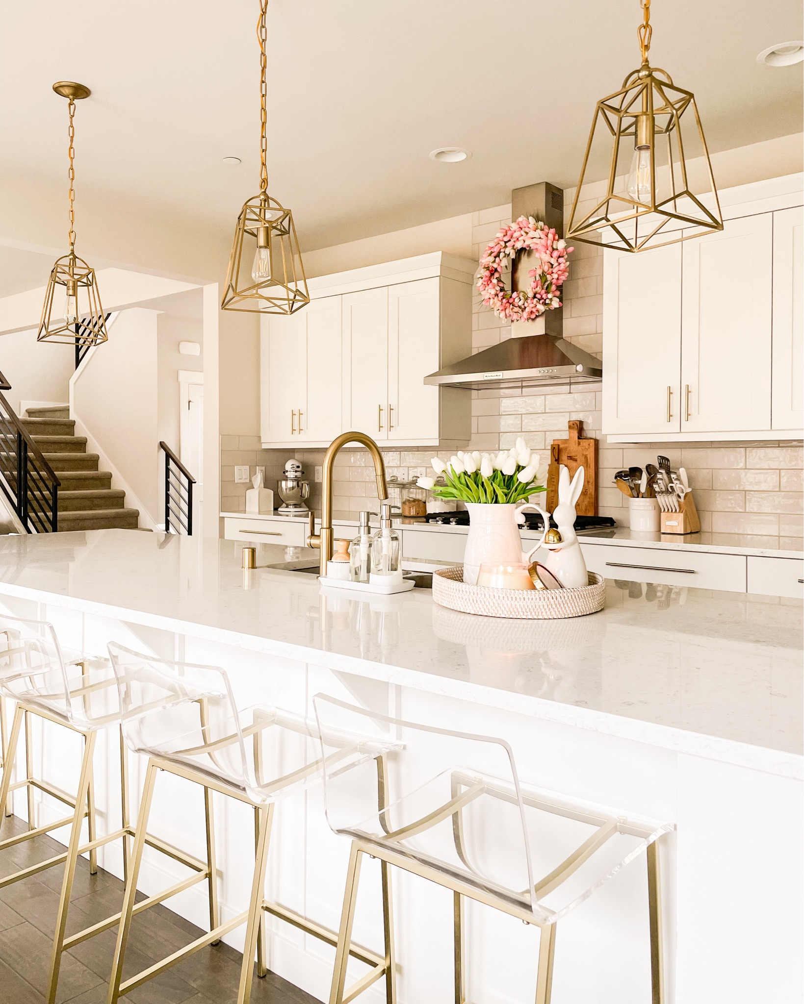 White kitchen with white cabinets, gold hardware, and brass pendant lights, good acrylic bar stools

#LTKSeasonal #LTKHome