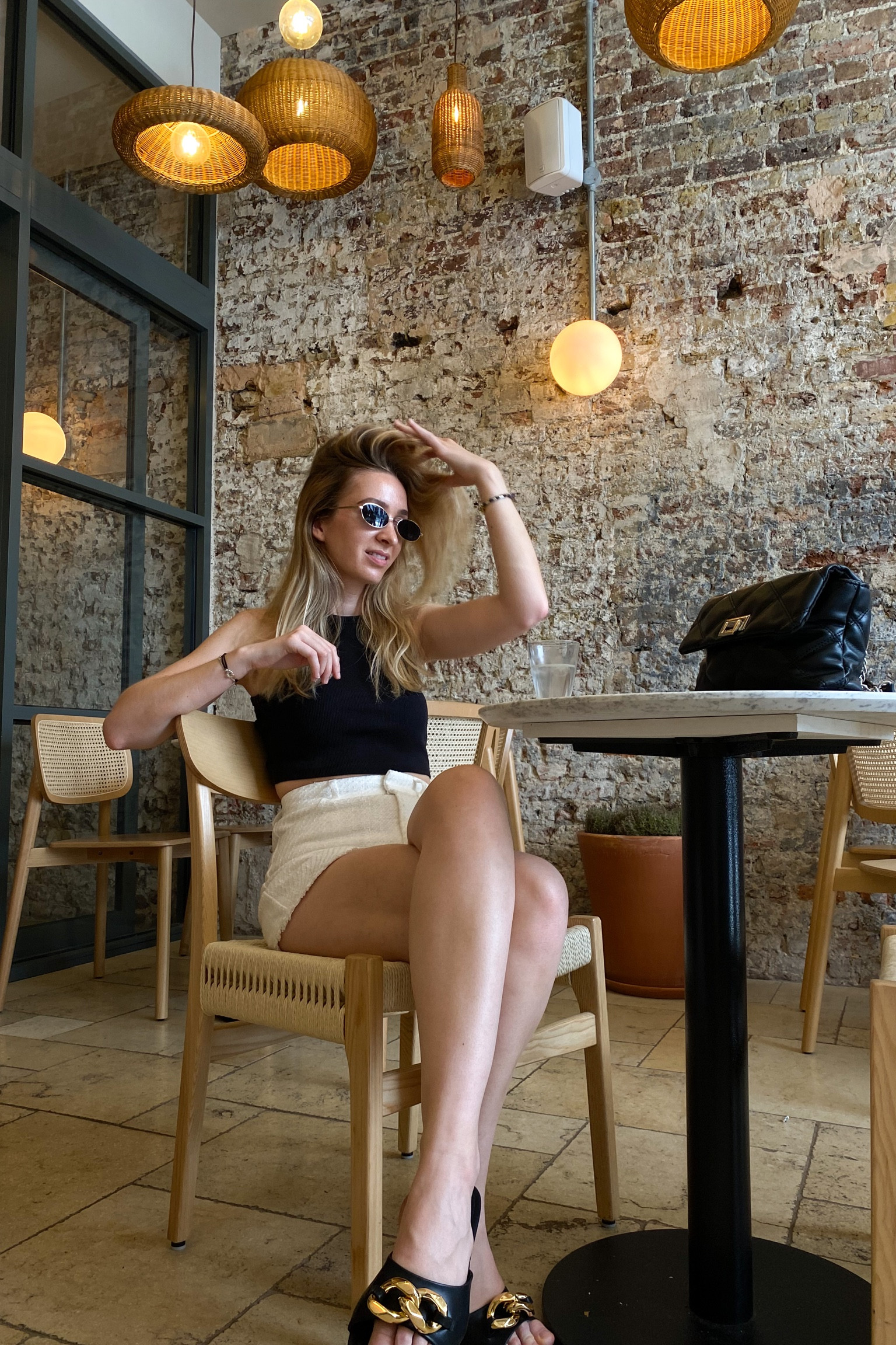 Summer outfit with white tailored shorts, black rib vest top, flat embellished sandals and oval sunglasses 

#LTKeurope