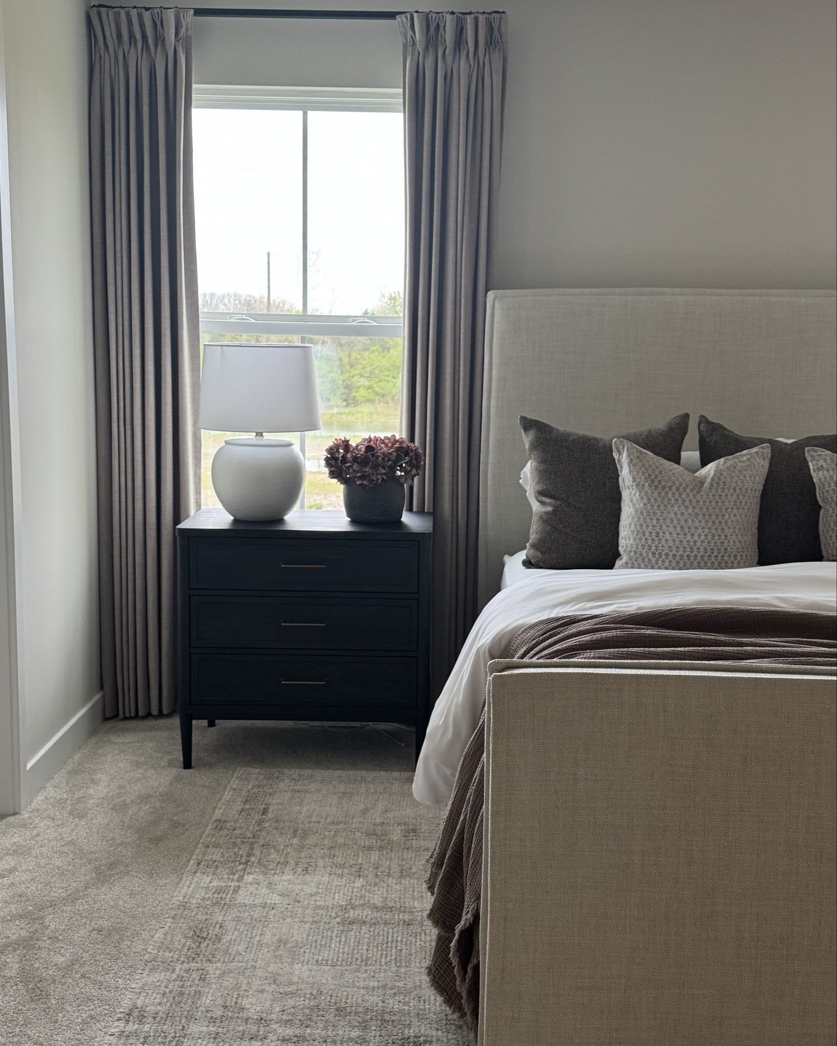 Plaid area rug, black nightstand, clay vase, brown throw, brown pillow cover, neutral pillow cover, floral pillow cover, bamboo duvet, neutral curtains, upholstered bed 

#LTKSeasonal #LTKHome #LTKSaleAlert