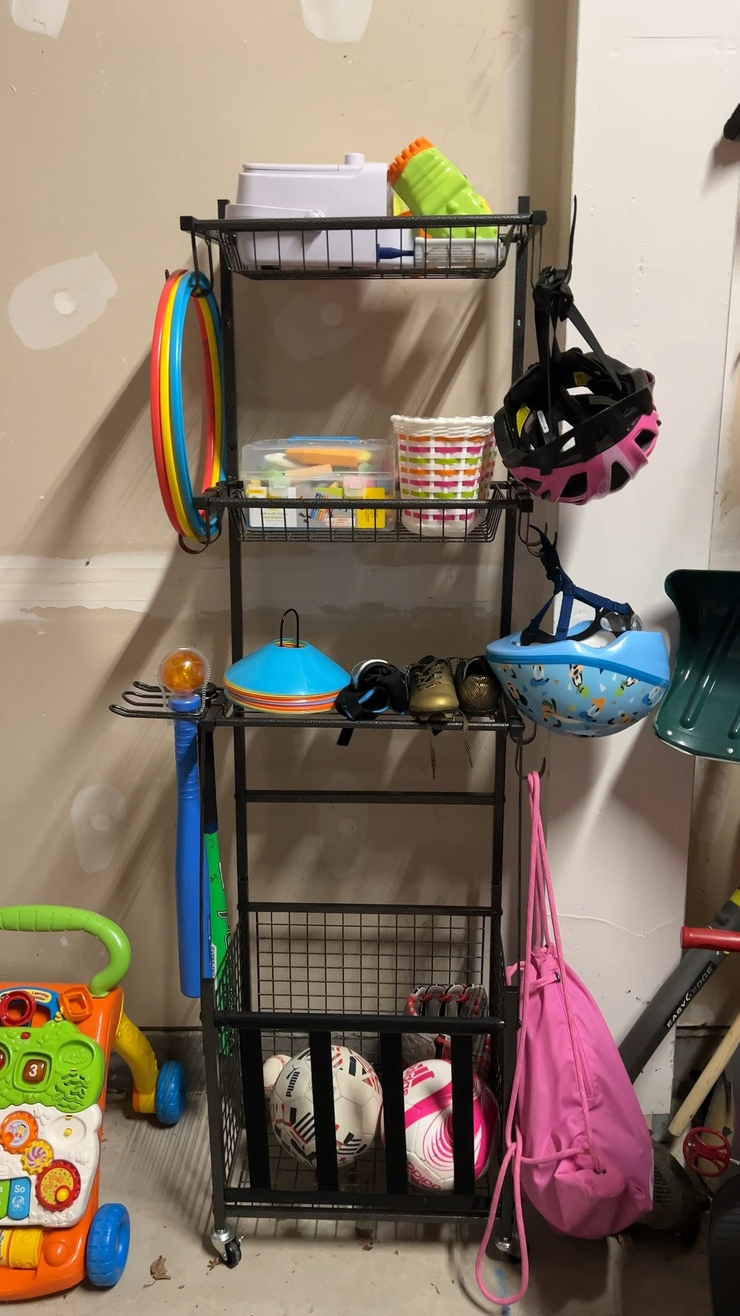 Cleaned and organized our garage this weekend and this garage sports organizer was the MVP! It's so easy for my kids to put away anything they are playing with and can be rolled in and out of the garage! We put their helmets/bars in the hooks, store all the balls in the bottom, then have some chalk and other outdoor toys on the shelves. Definitely a must have for outdoor toys! 

#LTKHome #LTKSaleAlert #LTKFindsUnder100