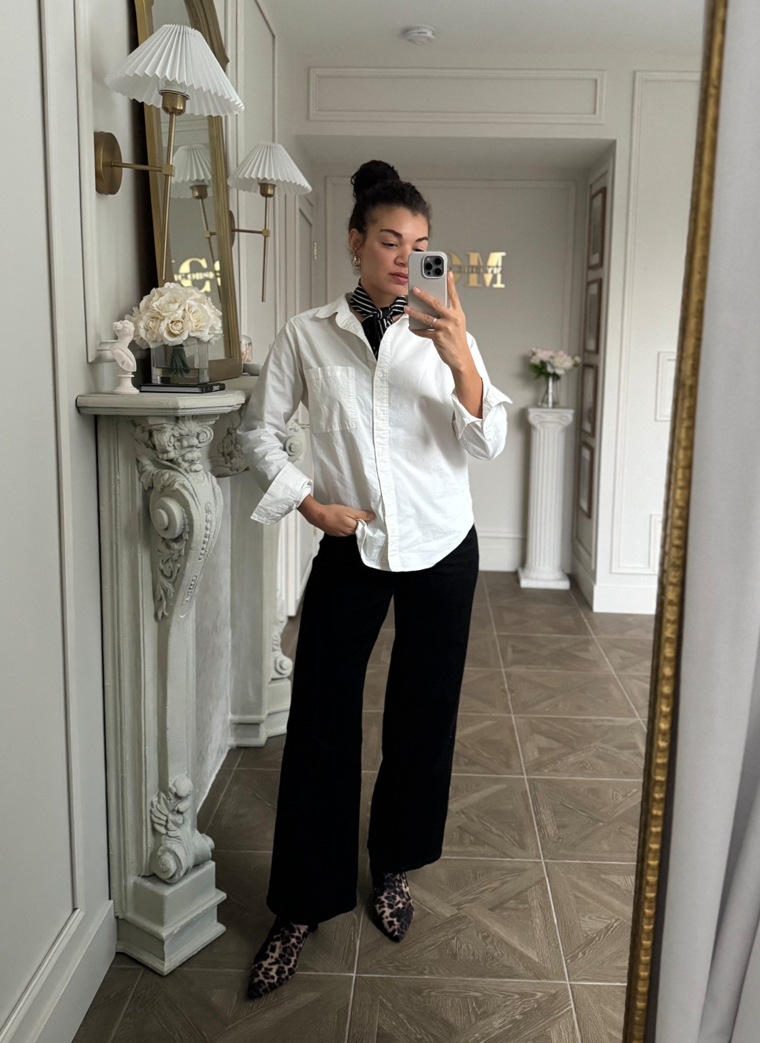 Casual chic jeans outfit with a white button up, black jeans, leopard print ankle boots, and a striped neck scarf 

#LTKootd