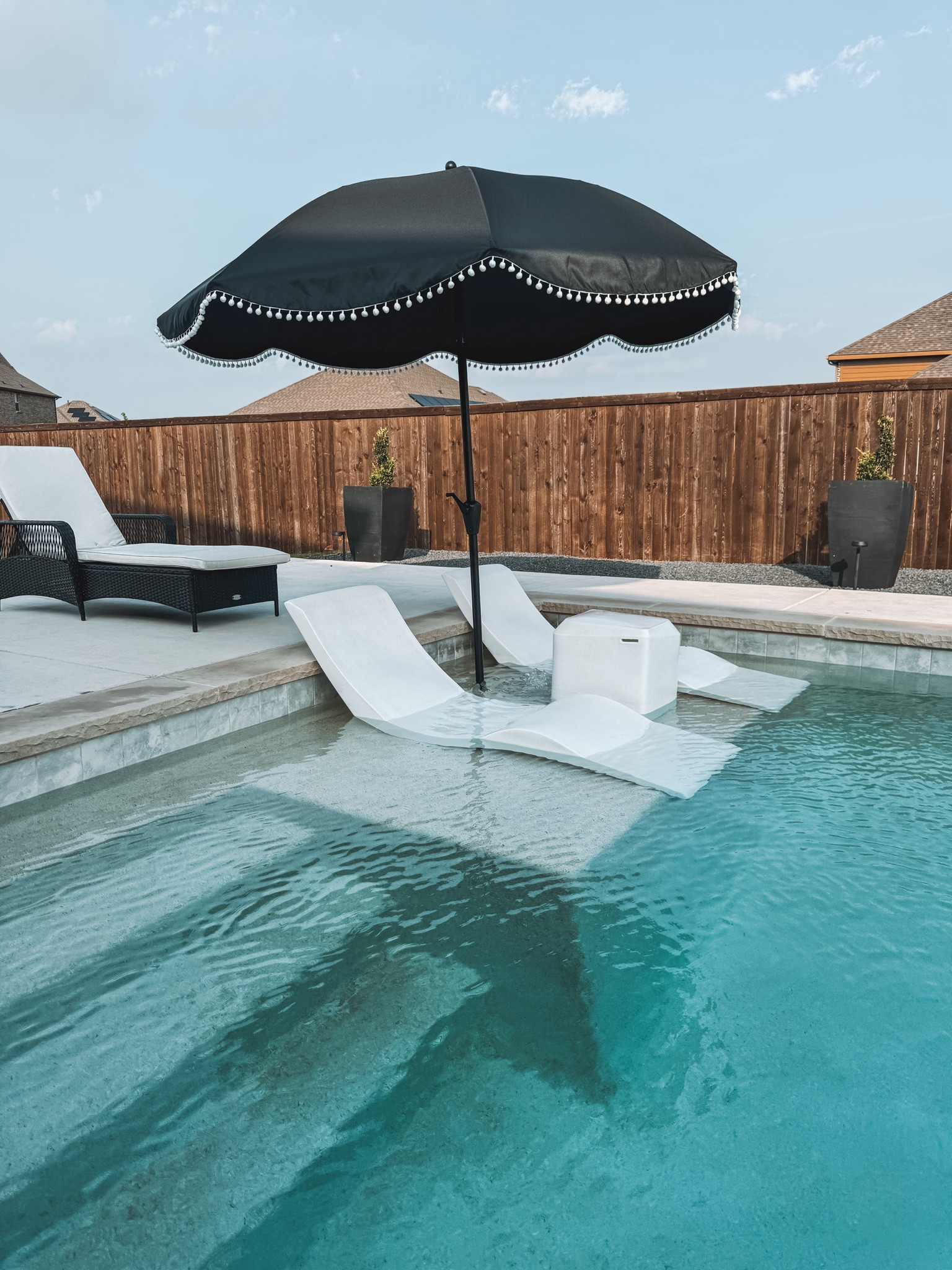 Outdoor patio umbrella and our ledge pool chase loungers! 
