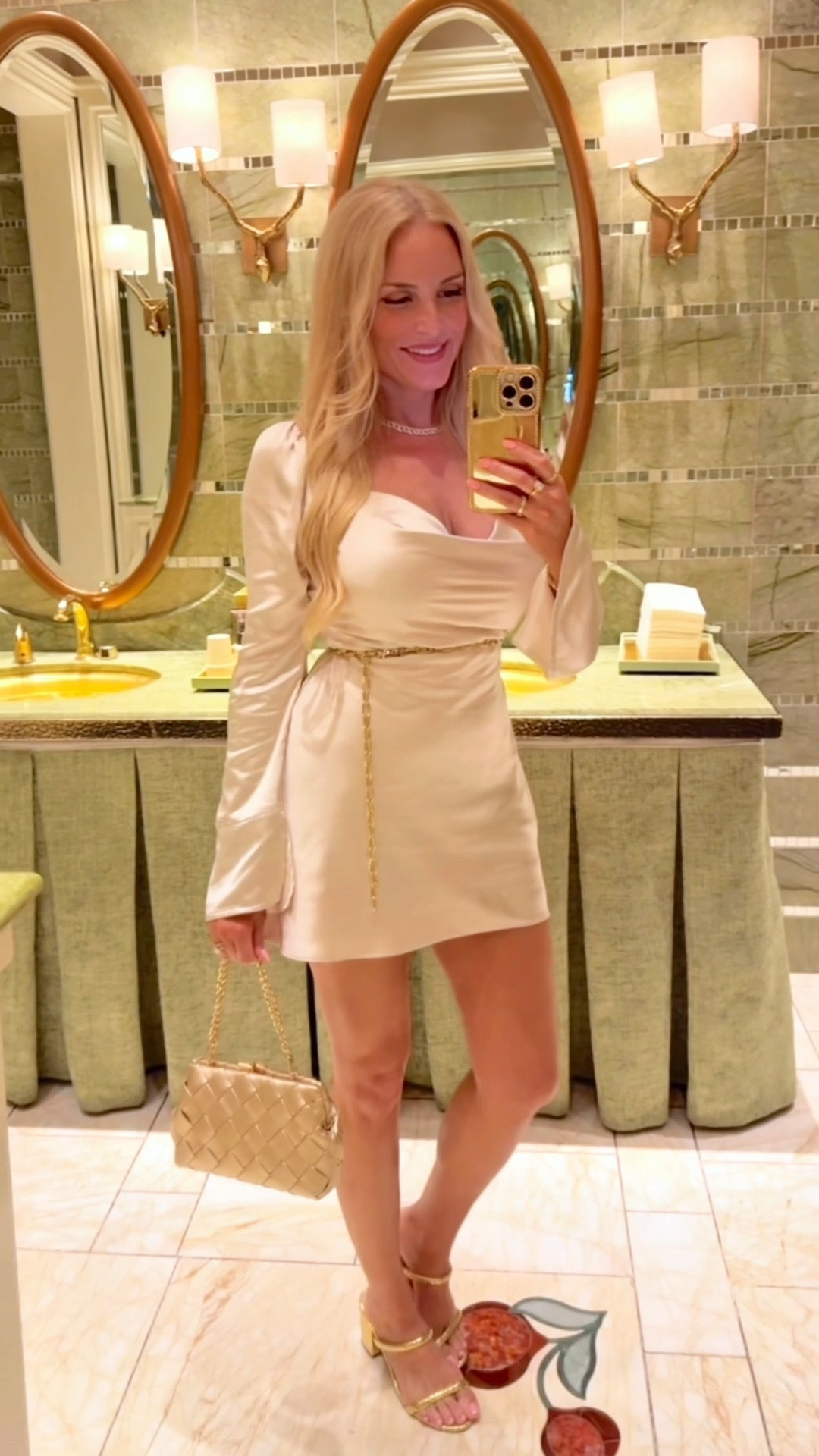 What I wore in Vegas to an upscale dinner and then a concert. I love this long sleeve satin mini dress so much that I got it on two colors. It is incredibly figure flattering! But VERY short, so be prepared to show a lot of leg. It's probably too short for taller ladies. I'm 5'5 and it just barely covers me in the back. I added a belt at the smallest part of my waist for a feminine silhouette. Linking some cute gold chain belts, sparkly gold jewelry and gold sandal heels for a fun Vegas night! 

#LTKStyleTip #LTKParties #LTKWatchNow
