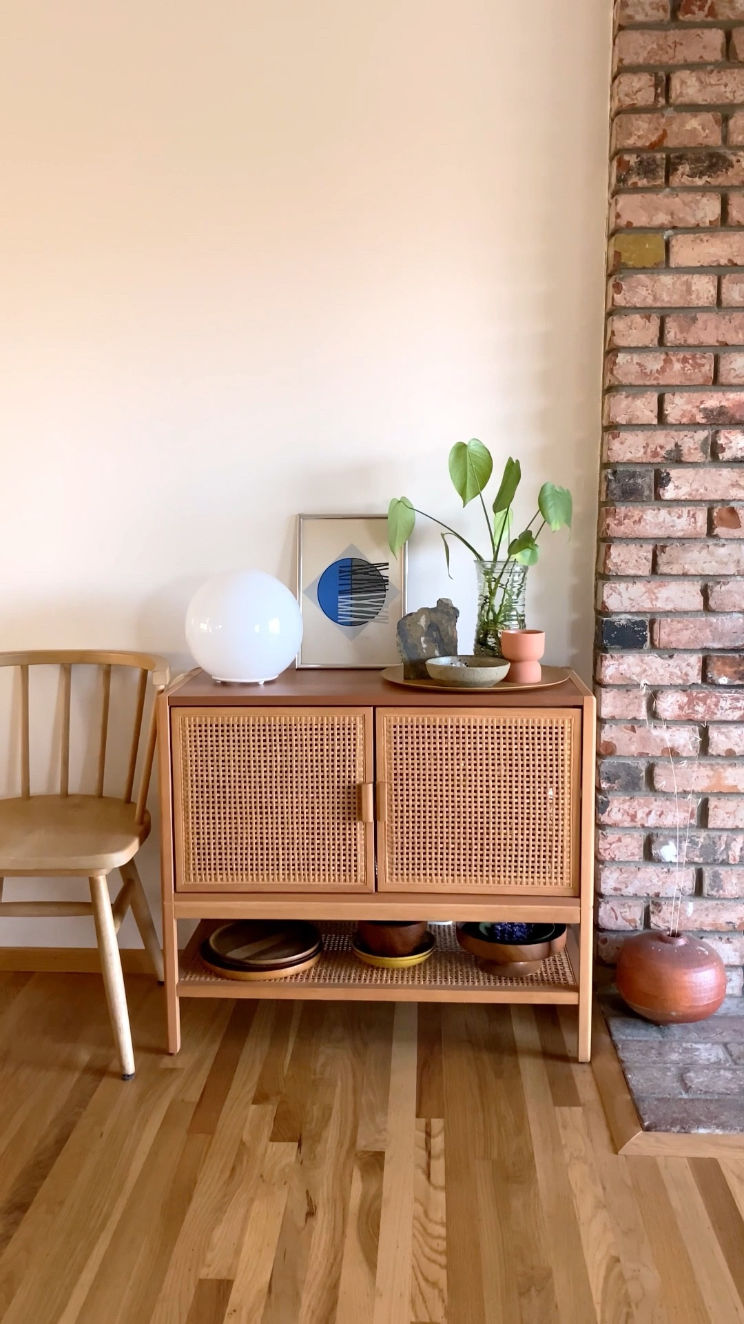 Style my caned console with me with a mix of antique and new goods// caned furniture, target caned console, hearth and hand with magnolia shaker chair, ikea fado bubble lamp, vintage De Soto lithograph, hunk of local jasper, vintage Japanese ceramic raku bowl, monstera propagation in wavy glass vase, large homemade ceramic vase, plus our thrifted collection of vintage wood serving plates and bowls

#LTKhome