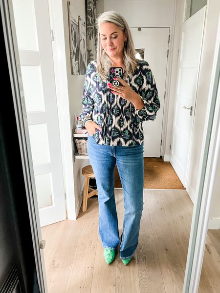 Outfits of the week. Blue and green printed blouse (secondhand Lonneke Nooteboom x Shoeby and used to be a dress) paired with tall flared jeans from Bershka and sustainable green Vivaia shoes. 

#LTKeurope #LTKover40 #LTKmidsize