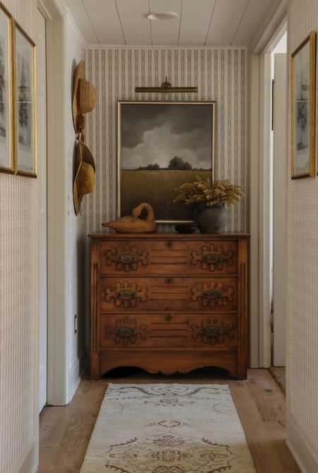 Our downstairs hallway sources. Similar wooden swans/geese and vintage black pots. Runner, hats and chest are all vintage. #wallpaper #oilpainting 
