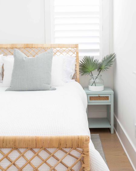 Our Florida carriage house bedroom featuring a rattan bed frame, Swedish blue herringbone rug, white waffle knit bedding, light blue and cane nightstands,  and faux palm leaves. Take the full tour here: https://lifeonvirginiastreet.com/our-florida-carriage-house-tour/
.
#ltkhome #ltkseasonal #ltkfindsunder50 #ltkfindunder100 #ltkstyletip #ltkover40 #ltktravel coastal bedroom decor, Serena & Lily style, neutral bedroom decor

#LTKhome #LTKsalealert #LTKSeasonal