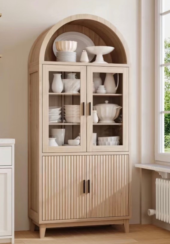 
A serene, light-filled interior featuring a tall arched light-oak cabinet with glass doors and fluted wood detailing on the lower panels. Shelves are styled with layered white ceramics, bowls, and sculptural pottery, creating a calm, curated look. Soft natural daylight streams through a nearby window, highlighting warm wood tones, subtle shadows, and organic textures. Modern European farmhouse aesthetic, quiet luxury styling, timeless design, ultra-realistic editorial interior photography.

⸻

Hashtags (25)

#ArchedCabinet
#NeutralHome
#OrganicModern
#QuietLuxuryHome
#EuropeanInspired
#WarmWoodTones
#TimelessInteriors
#StyledShelves
#NeutralDecor
#MinimalLuxury
#ModernTraditional
#HomeInspo
#InteriorAesthetic
#CalmLiving
#ArchitecturalDetails
#SoftNeutrals
#OrganicTextures
#ElevatedInteriors
#HomeEdit
#ModernFarmhouse
#InteriorStyling
#DesignInspiration
#CozyMinimal
#NaturalMaterials
#EffortlessStyle



#LTKHoliday #LTKGiftGuide #LTKdayinmylife