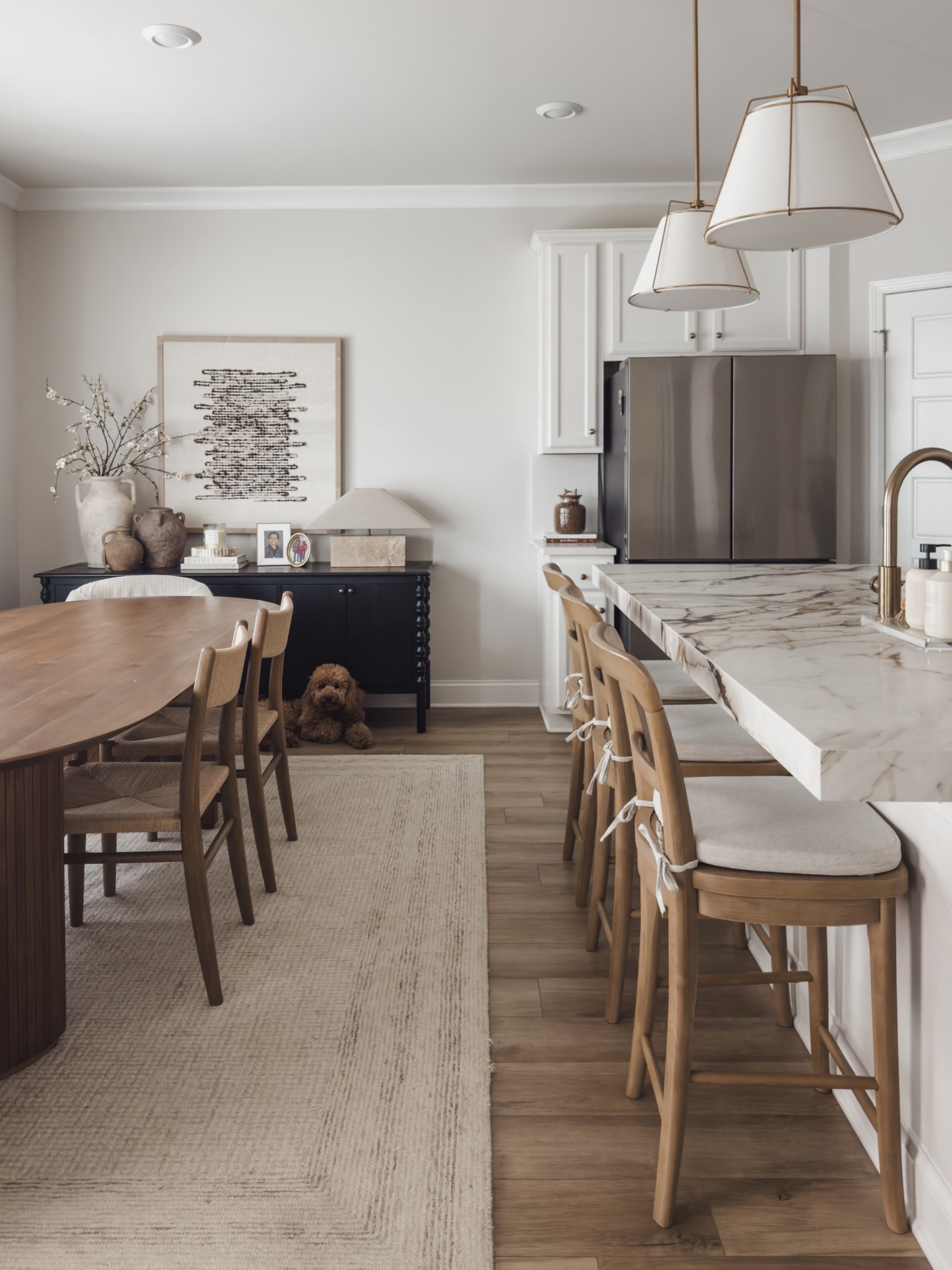 Bright and airy dining room and kitchen space! Featuring my seadrift colored counter stools and Amazon cushions for comfort. 

Also, sharing my new sideboard from Home and Kids Co that is a great alternative for the Lulu and Georgia sideboard! 

Home decor, dining room style, warm wood furniture, Loloi finds, rugs in my home, fabric art, home inspo, shop the look! 

#LTKSaleAlert #LTKHome #LTKFindsUnder100