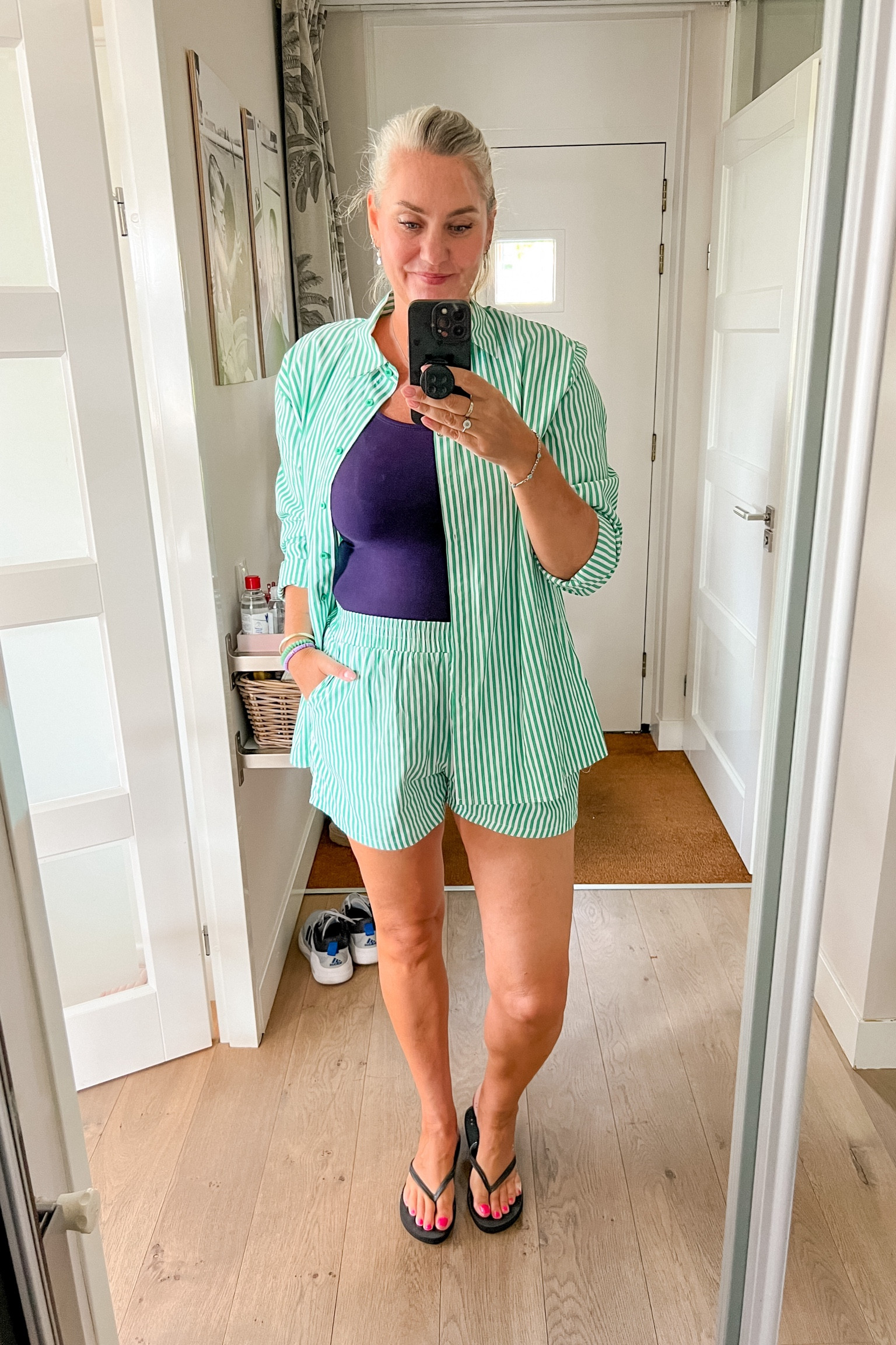 Green, tall, striped co-ord consisting of a buttondown shirt and boxer style shorts. Paired with a purple tank top and basic black flip flops. 



#LTKeurope #LTKsummer #LTKnederlands