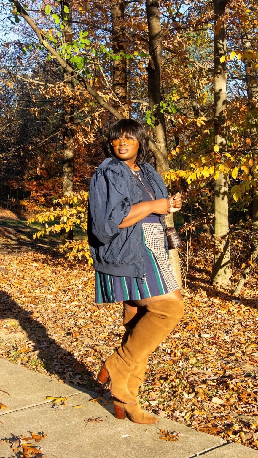 Sometimes one statement piece can pull an entire outfit together. These cognac knee-high suede boots add warmth and texture to a patterned mini skirt, while the navy jacket keeps the look casual.  fall outfit ideas, fall fashion for women, knee-high suede boots outfit, cognac brown boots, mini skirt outfit ideas, oversized jacket outfit, how to mix prints, plus-size fall fashion, autumn street style, fall wardrobe essentials. @Walmart @Target @ASOS