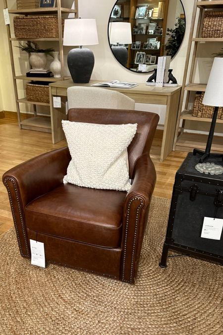 Classic leather swivel chair with nailheads and natural fiber rug from Pottery Barn.  Also textured cream throw pillow, round mirror, black lamp and black dog bookends. 

#ltkpotterybarn #ltkchair

#LTKhome #LTKstyletip