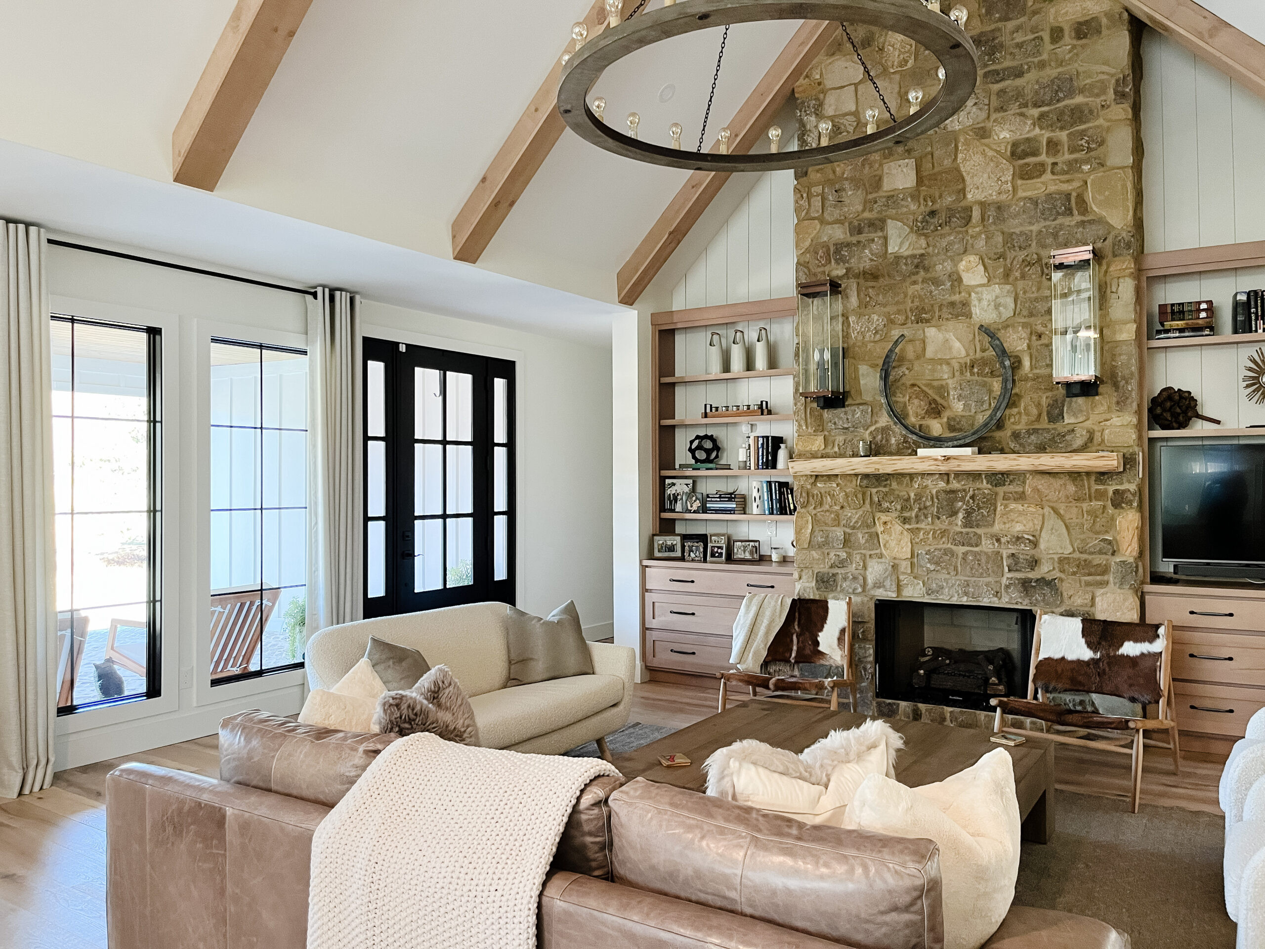 ✨ Rustic meets refined in this open-concept modern farmhouse. From the vaulted ceiling with stained beams to the stunning stone fireplace and statement lighting, every detail blends warmth and sophistication. Raw materials, cozy textures, and sculptural accents make this space the perfect mix of old and new. 🪵✨ Shop the look and bring modern farmhouse charm home. 

 #ModernFarmhouse #LTKHome #RusticStyle