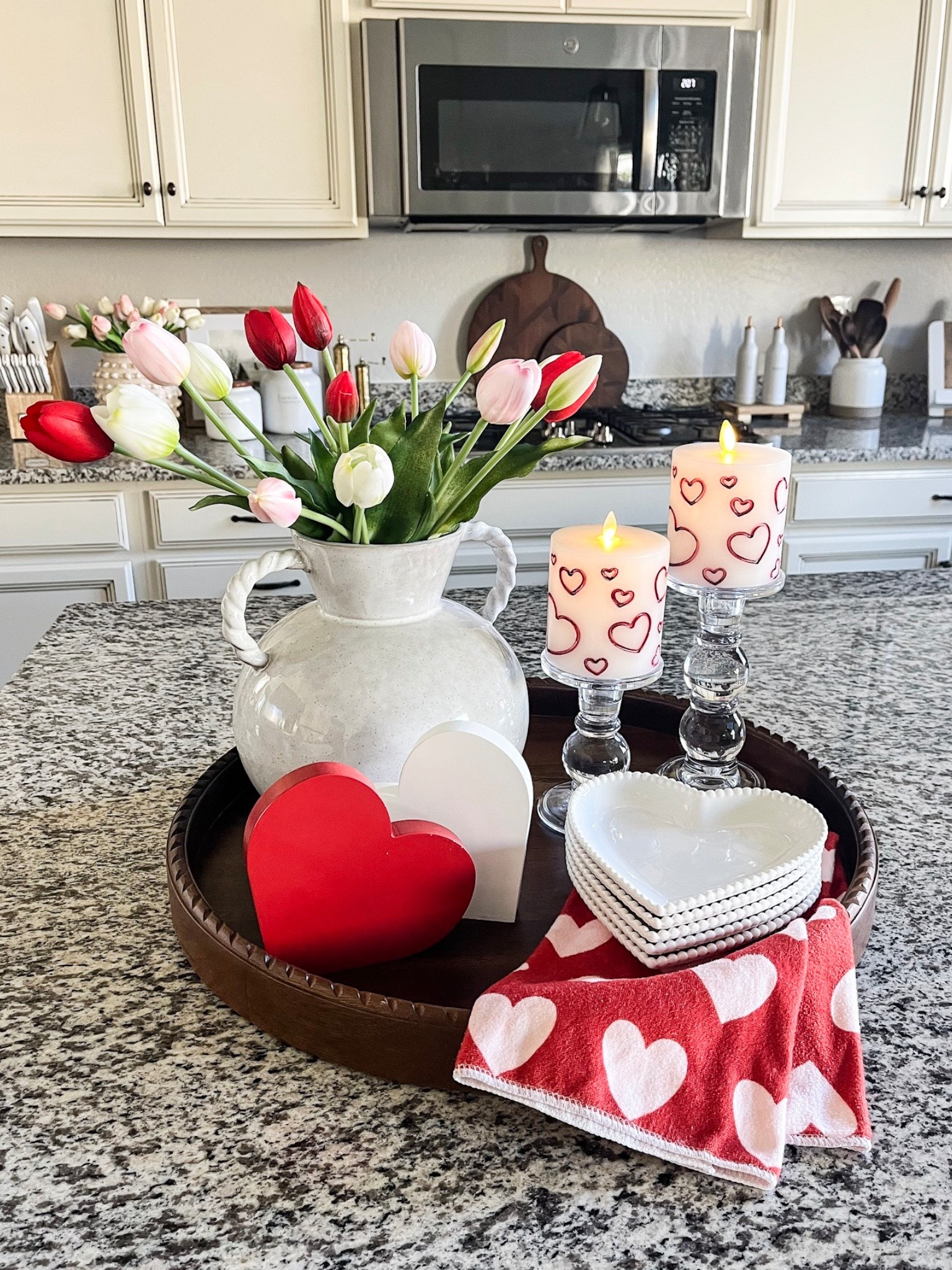 VALENTINE'S DAY tray styling! 

Follow @lifeinmyarizonahome
on Instagram for more inspiration.

These beautiful tulips are so realistic looking and I love the gorgeous detail on the heart plates. The luminara flameless candles are my absolute favorite and so realistic looking. The heart design is just adorable right now!  This is such a simple way to add a few Valentines touches to your home  

Wood round tray | real touch tulips | glass candle holder | luminara flameless heart candle | wood heart decor | heart towel | white heart plates

#valentinesdecor #traystyling
#homedecor



#LTKSeasonal #LTKHome #LTKValentine