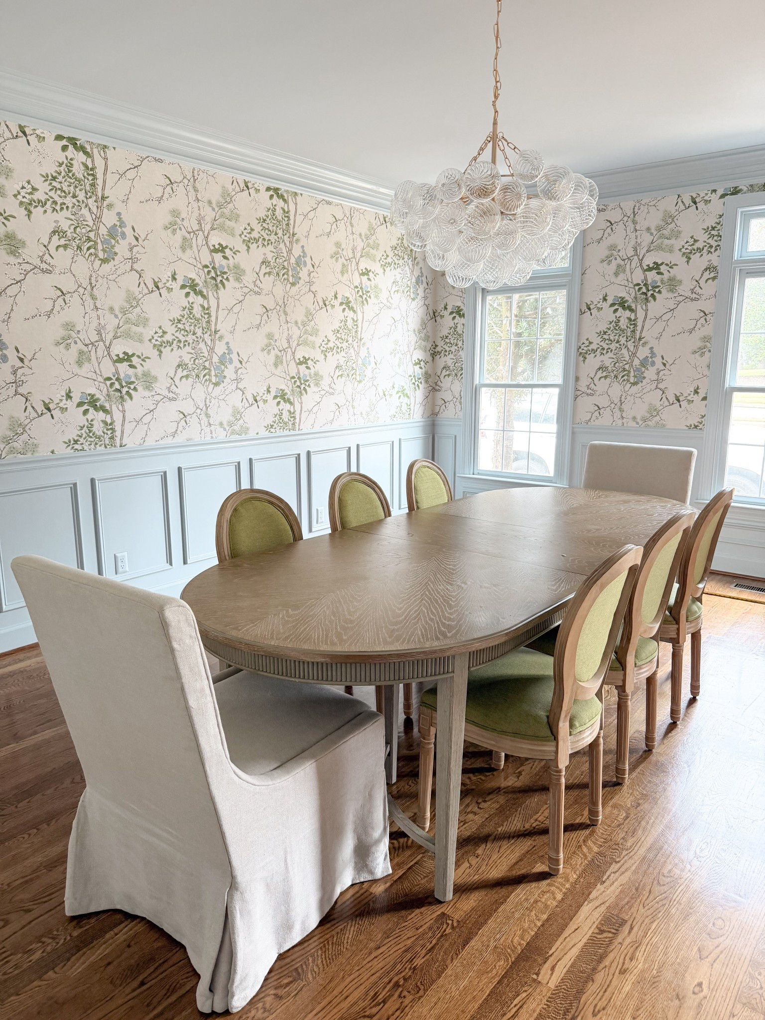 Southern style dining room with chintz floral wallpaper, oval dining table and green upholstered dining
Chairs. Bubble chandelier from Amazon. Trim color, Brittany blue by BM 

#LTKHome