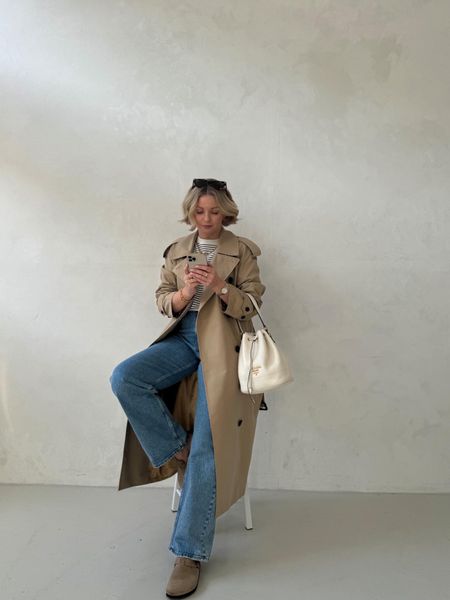 Everyday spring outfit idea - Abercrombie straight leg 90s blue jeans, Birkenstock bostons, white prada bucket bag, cos clean cut striped t shirt, trench coat, Monica vinader gold snake chain necklace  

#LTKeurope #LTKstyletip #LTKSeasonal