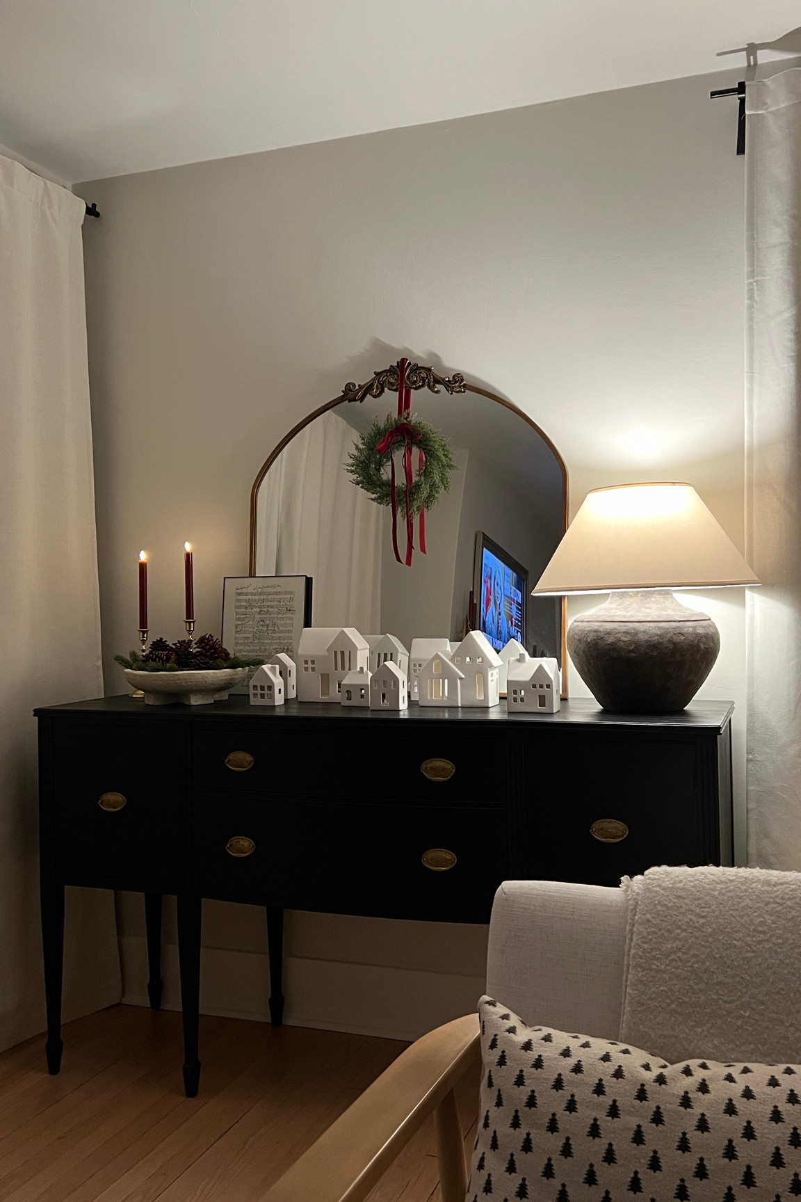 Sideboard table decorated for Christmas with a mini wreath, table lamp, ceramic Christmas village, and battery candlesticks ❤️ 

#LTKSeasonal #LTKHoliday #LTKhome